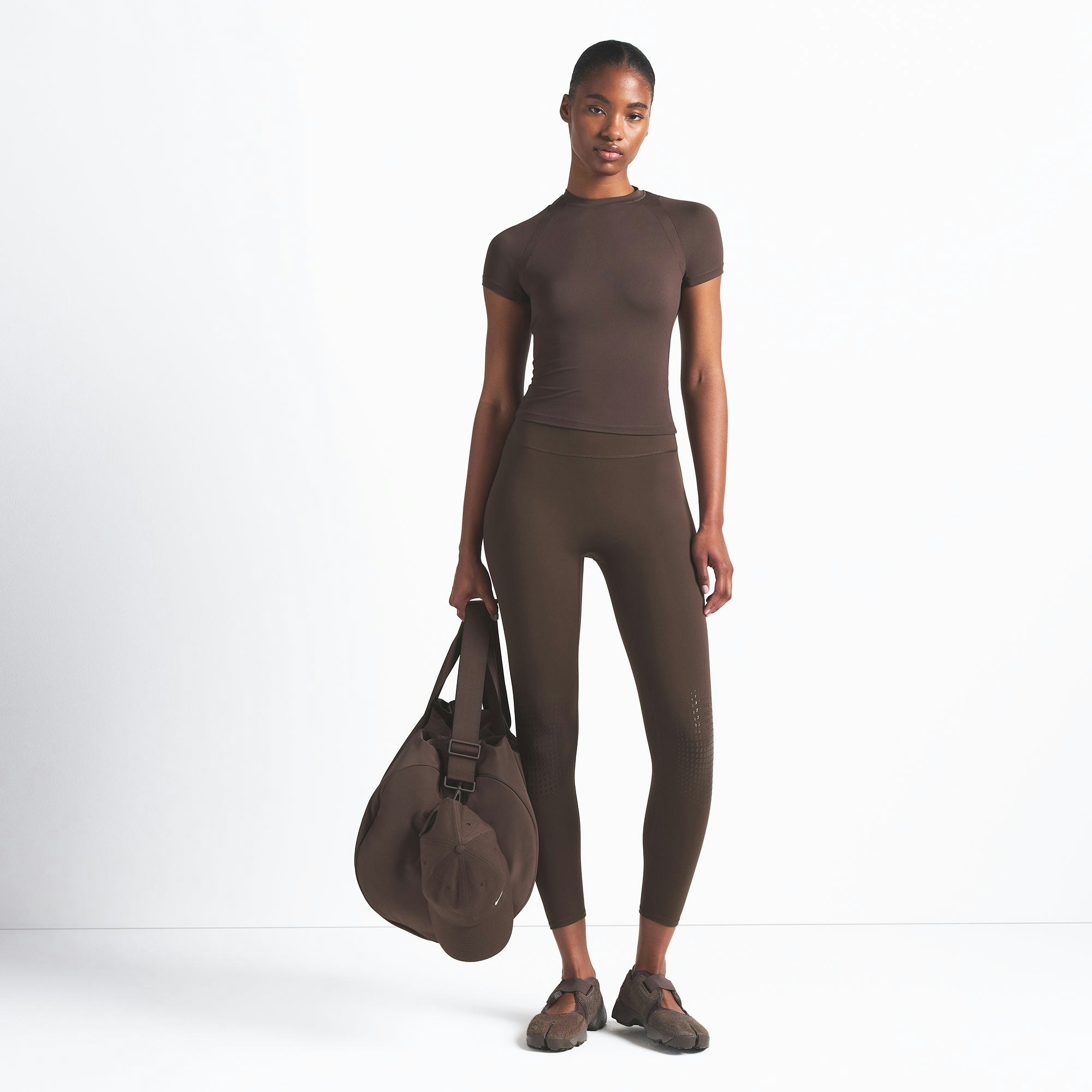 NikeSKIMS AIRY BABY TEE | DARK SEPIA ON A MODEL FRONT VIEW @ | FOCUS: 0.9, 0.1, 0.7