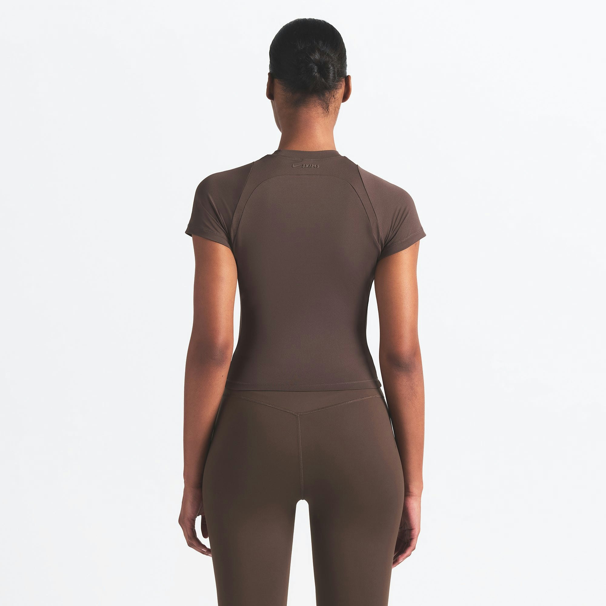 NikeSKIMS AIRY BABY TEE | DARK SEPIA ON A MODEL SIDE VIEW @ | FOCUS: 0.9, 0.1, 0.7