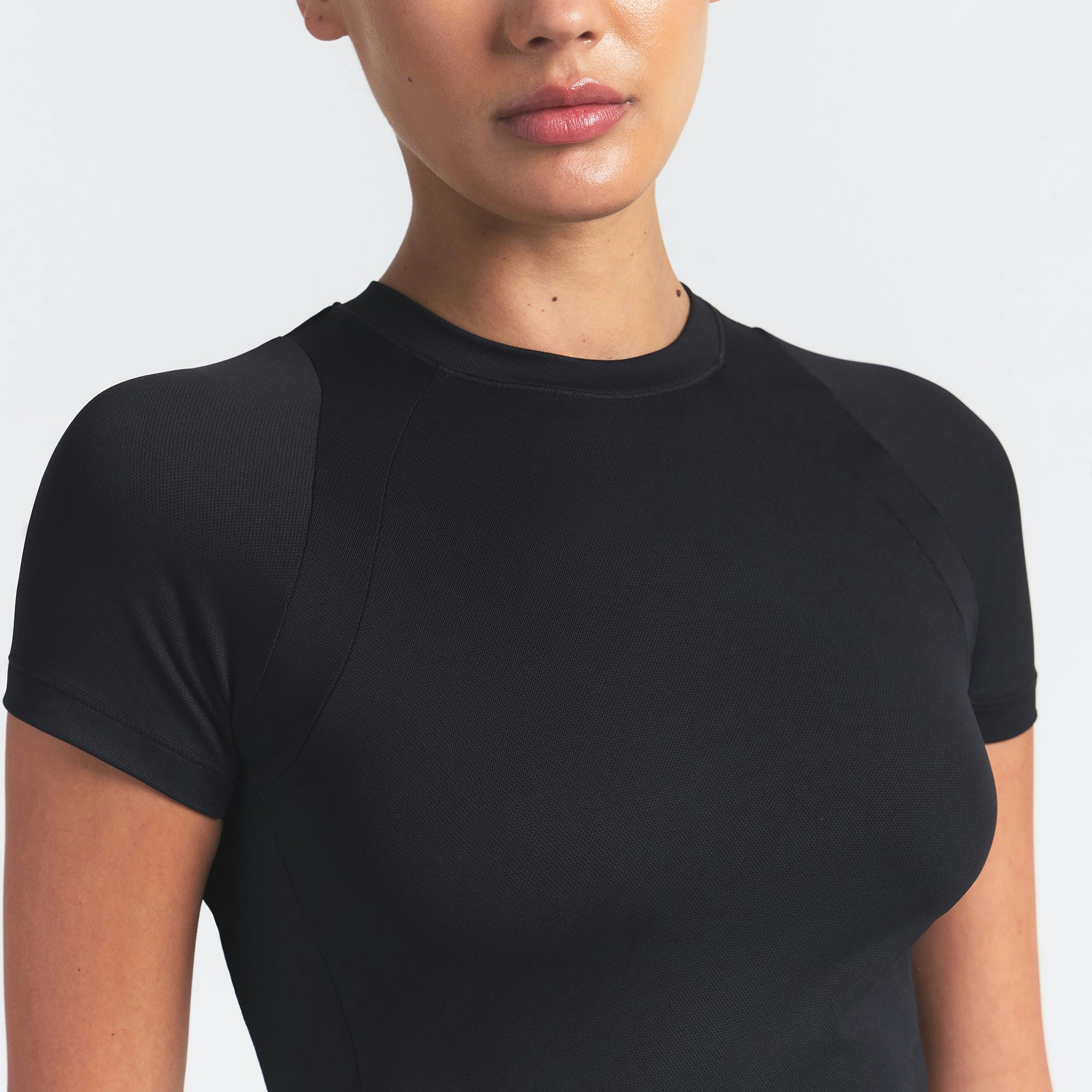 NikeSKIMS AIRY BABY TEE | OBSIDIAN ON A MODEL SIDE VIEW @ | FOCUS: 0.9, 0.1, 0.7