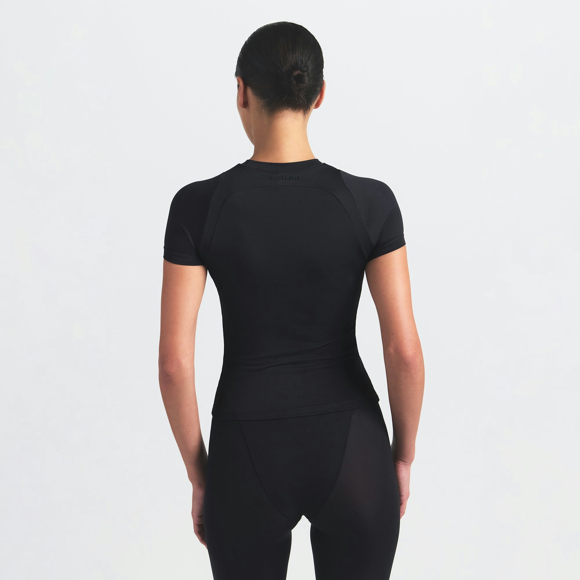 NikeSKIMS AIRY BABY TEE | OBSIDIAN ON A MODEL SIDE VIEW @ | FOCUS: 0.9, 0.1, 0.7