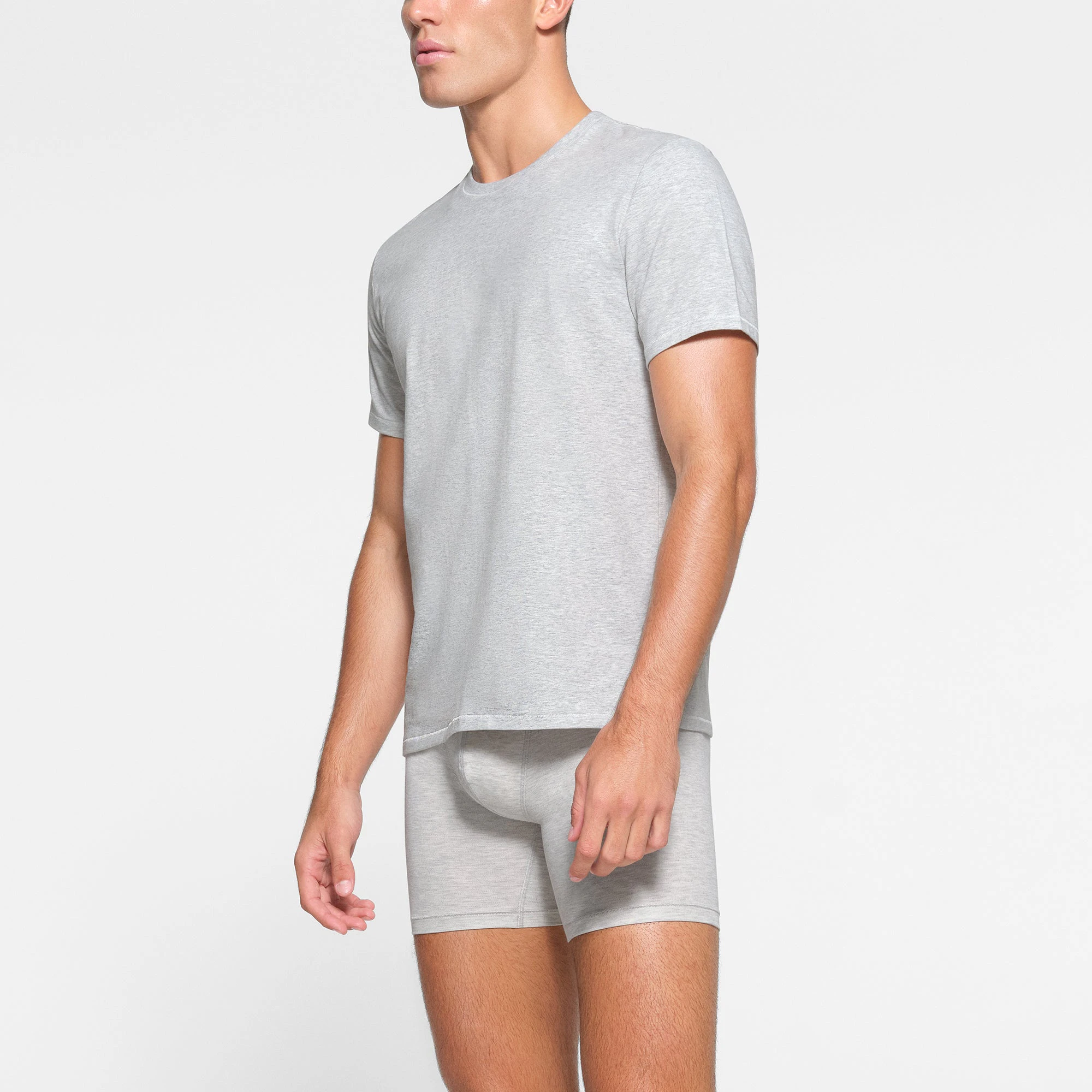 SKIMS COTTON MENS T-SHIRT WORN BY A MODEL IN SIDE VIEW