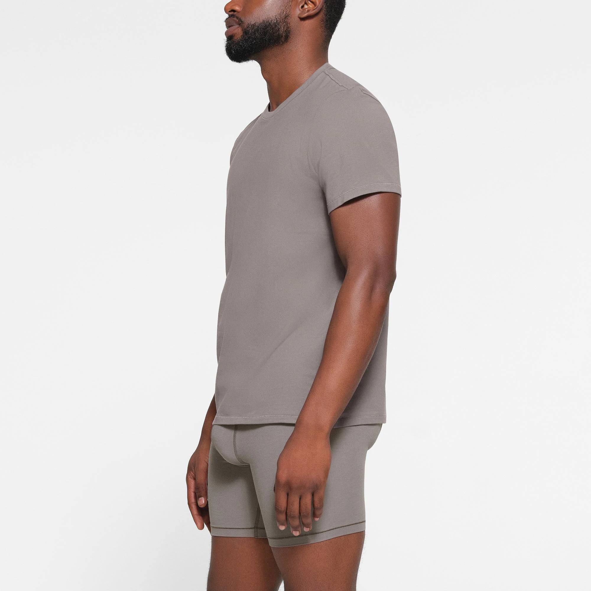 SKIMS COTTON MENS T-SHIRT WORN BY A MODEL IN SIDE VIEW