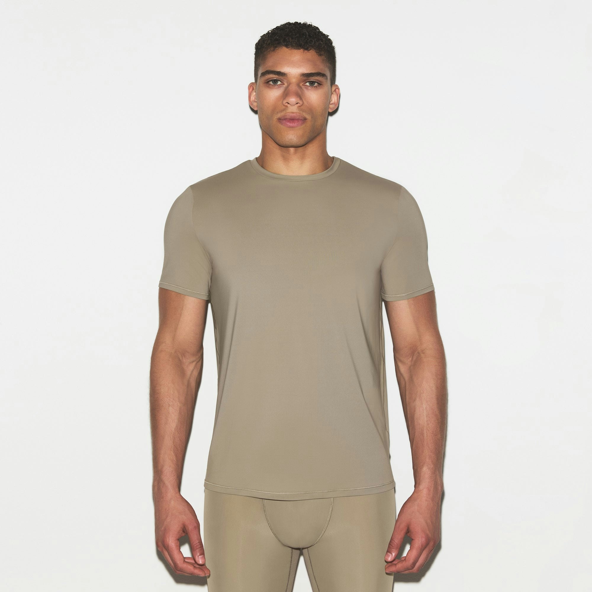 SKIMS FLEX MENS T-SHIRT | DUNE ON A MODEL FRONT VIEW @ | FOCUS: 0.0, 1.0, 0.9