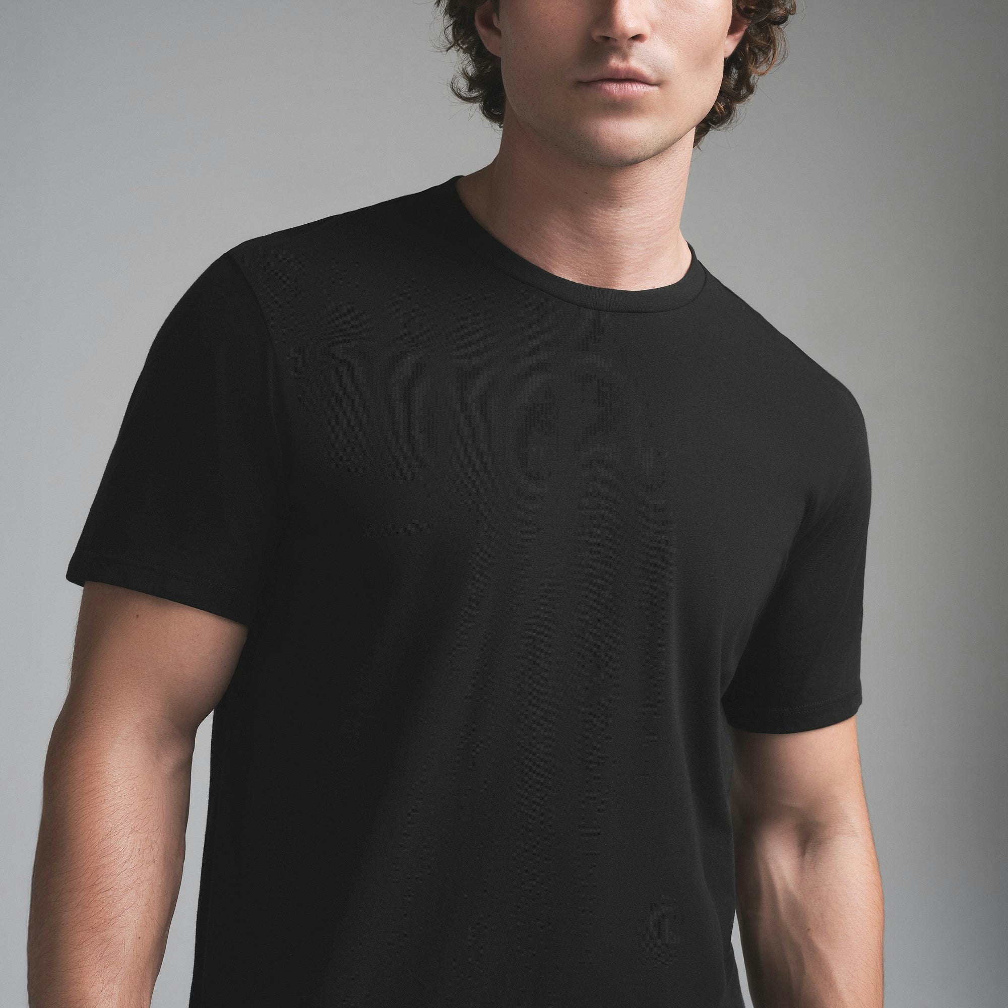 SKIMS COTTON MENS CLASSIC T-SHIRT | ONYX ON A MODEL SIDE VIEW | FOCUS: 0.0, 1.0, 0.9