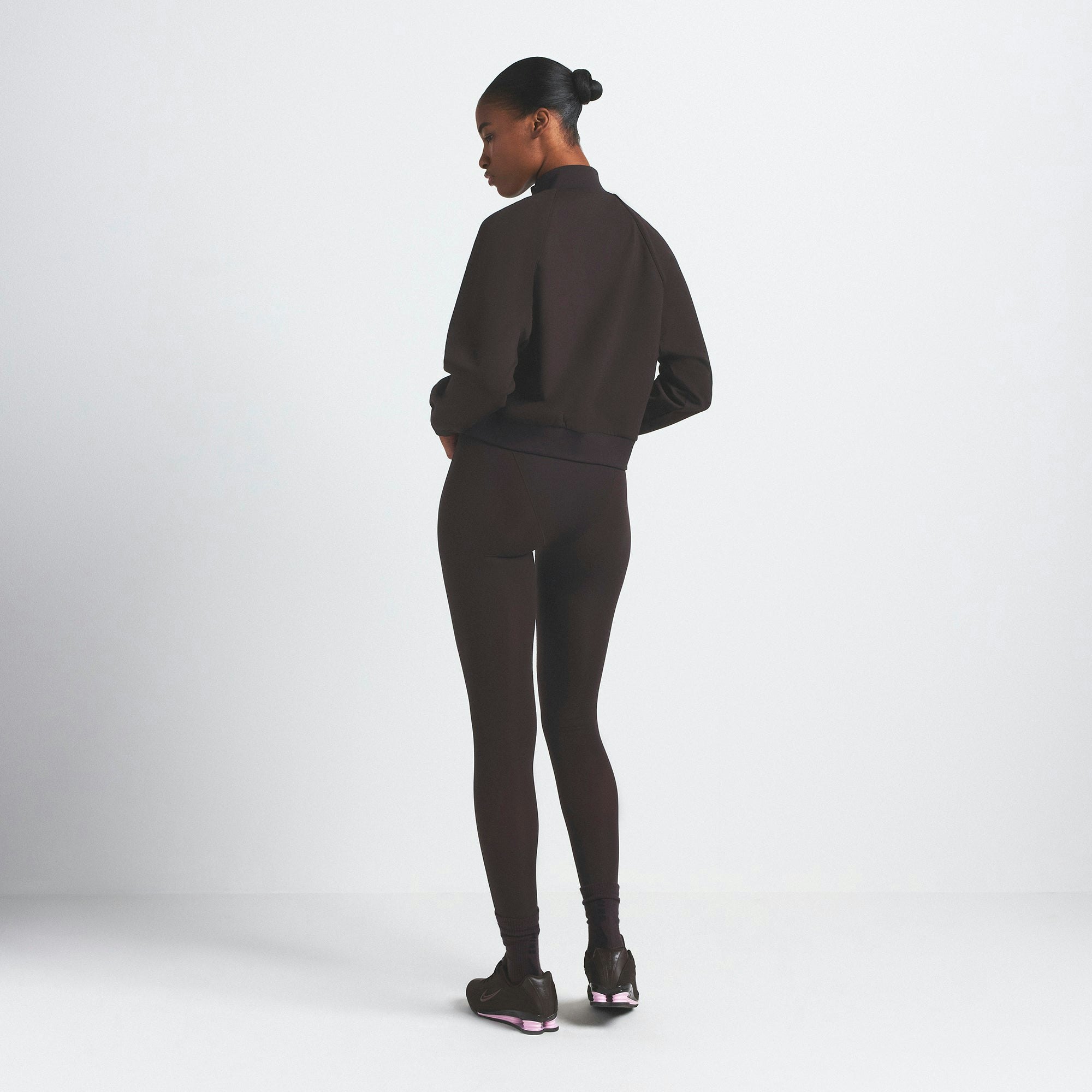NikeSKIMS MATTE TRICOT TRACK JACKET | DARK ROAST ON A MODEL SIDE VIEW @ | FOCUS: 0.0, 1.0, 0.9