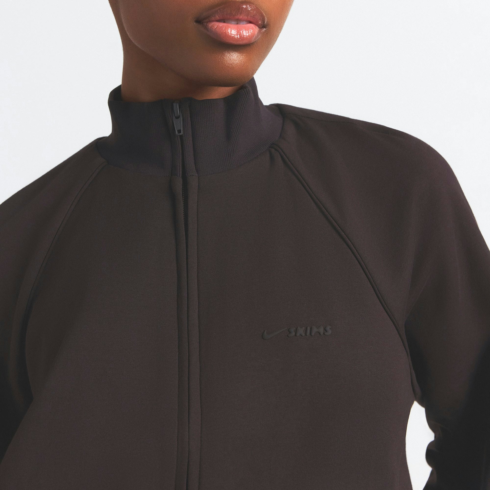 NikeSKIMS MATTE TRICOT TRACK JACKET | DARK ROAST ON A MODEL SIDE VIEW @ | FOCUS: 0.0, 1.0, 0.9