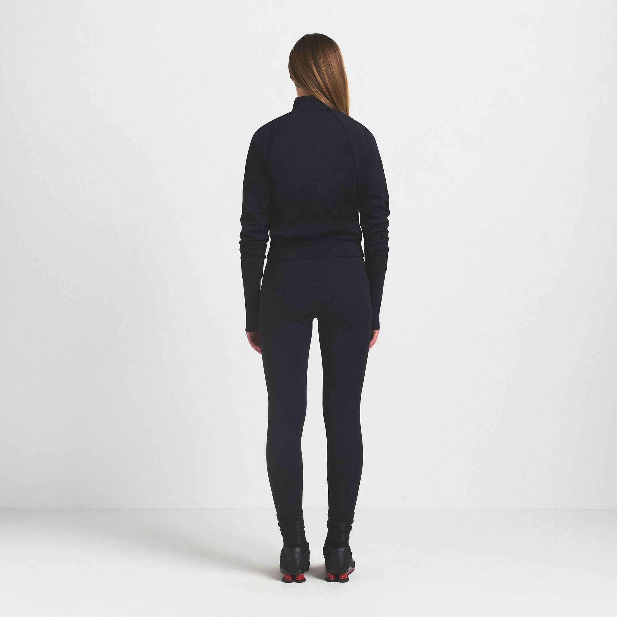 NikeSKIMS MATTE TRICOT TRACK JACKET | OBSIDIAN ON A MODEL SIDE VIEW @ | FOCUS: 0.9, 0.1, 0.7