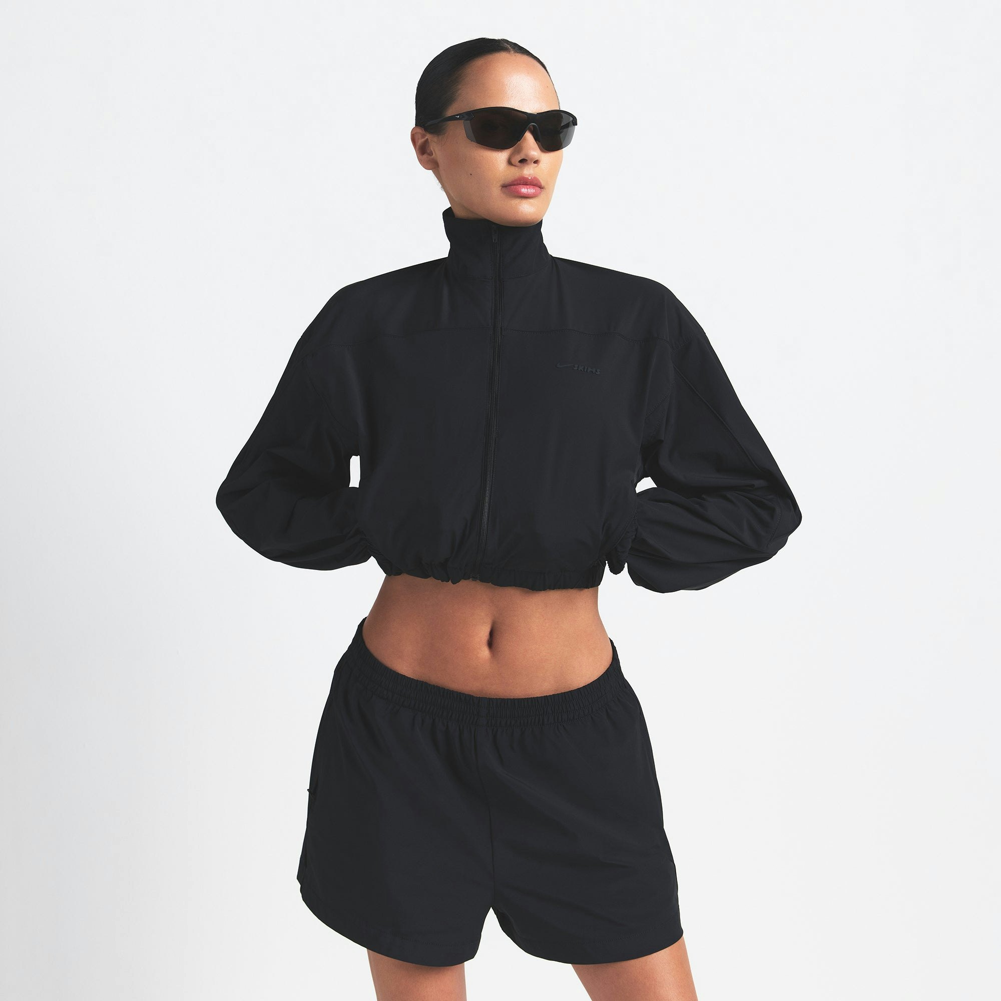 NikeSKIMS WOVEN NYLON CROP JACKET | OBSIDIAN ON A MODEL FRONT VIEW @ | FOCUS: 0.0, 1.0, 0.9