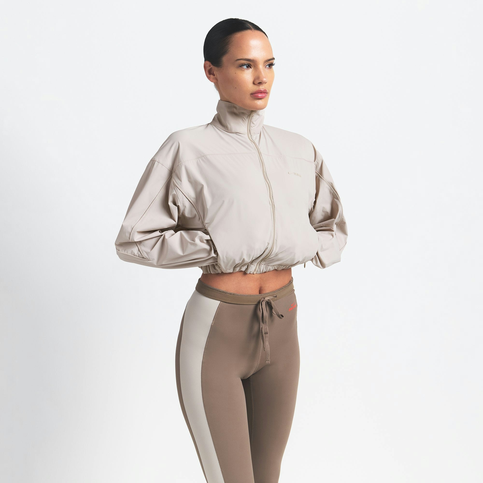 NikeSKIMS WOVEN NYLON CROP JACKET | STONE ON A MODEL SIDE VIEW @ | FOCUS: 0.0, 1.0, 0.9