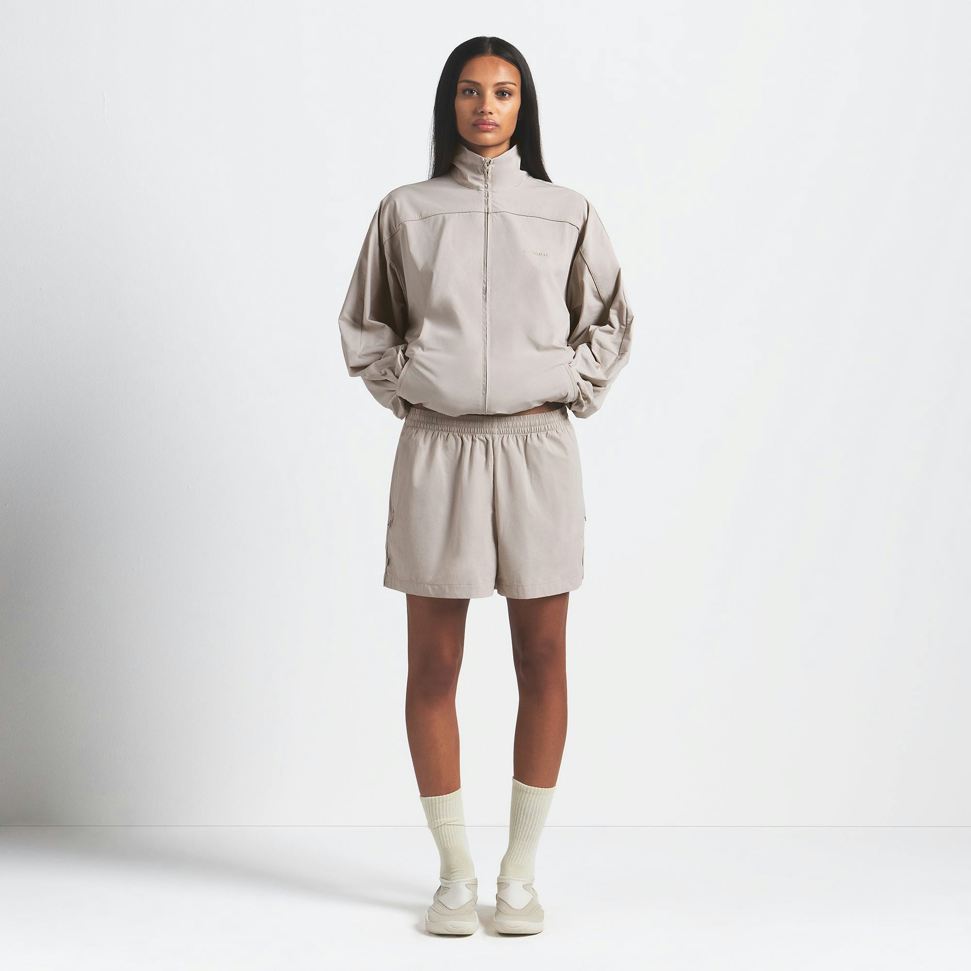 NikeSKIMS WOVEN NYLON OVERSIZED TRACK JACKET | STONE ON A MODEL FRONT VIEW @ | FOCUS: 0.0, 1.0, 0.9