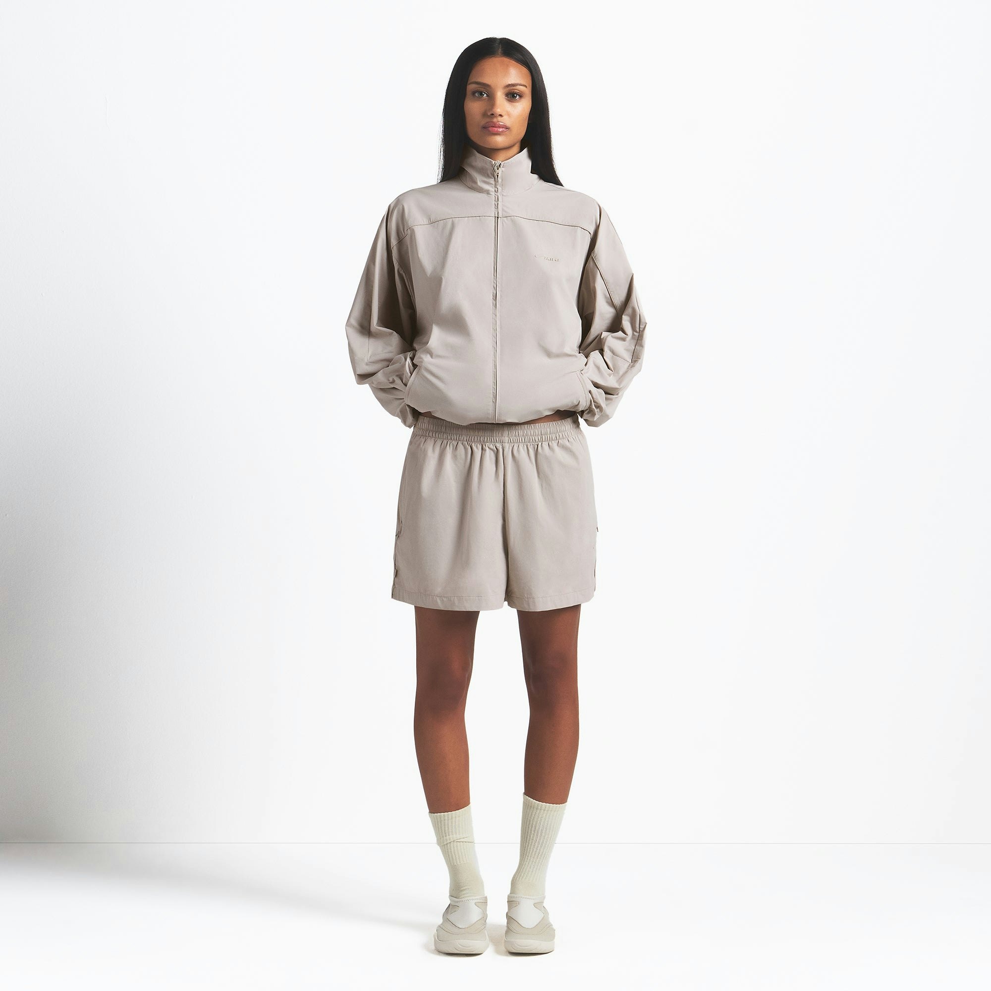 NikeSKIMS WOVEN NYLON OVERSIZED TRACK JACKET | STONE ON A MODEL FRONT VIEW @ | FOCUS: 0.0, 1.0, 0.9