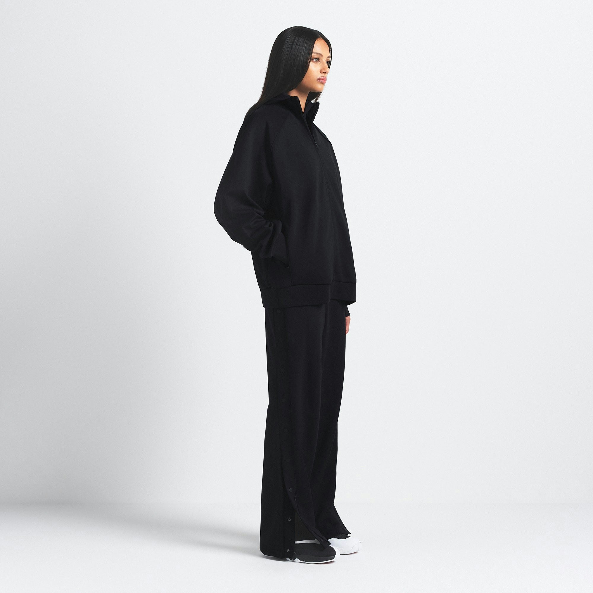 NikeSKIMS MATTE TRICOT OVERSIZED TRACK JACKET | OBSIDIAN ON A MODEL SIDE VIEW @ | FOCUS: 0.9, 0.1, 0.7