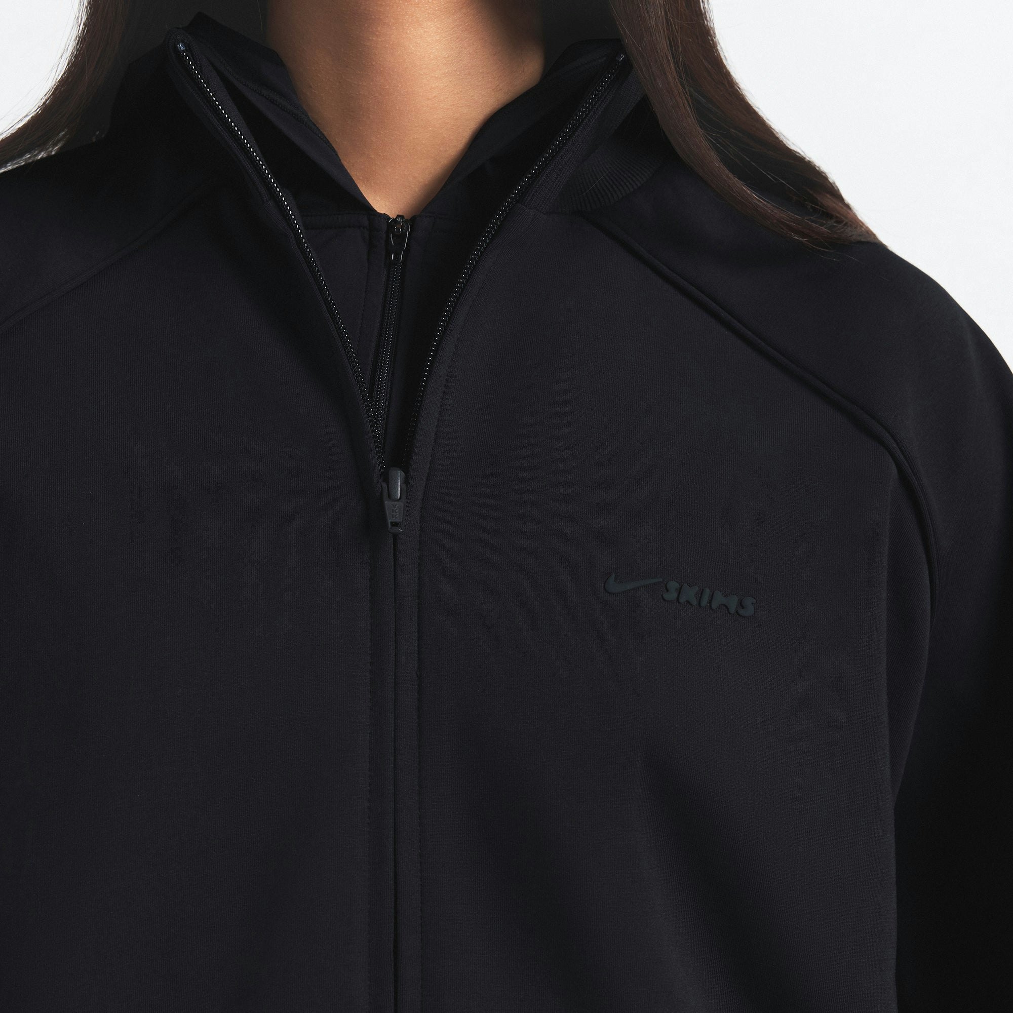 NikeSKIMS MATTE TRICOT OVERSIZED TRACK JACKET | OBSIDIAN ON A MODEL SIDE VIEW @ | FOCUS: 0.9, 0.1, 0.7