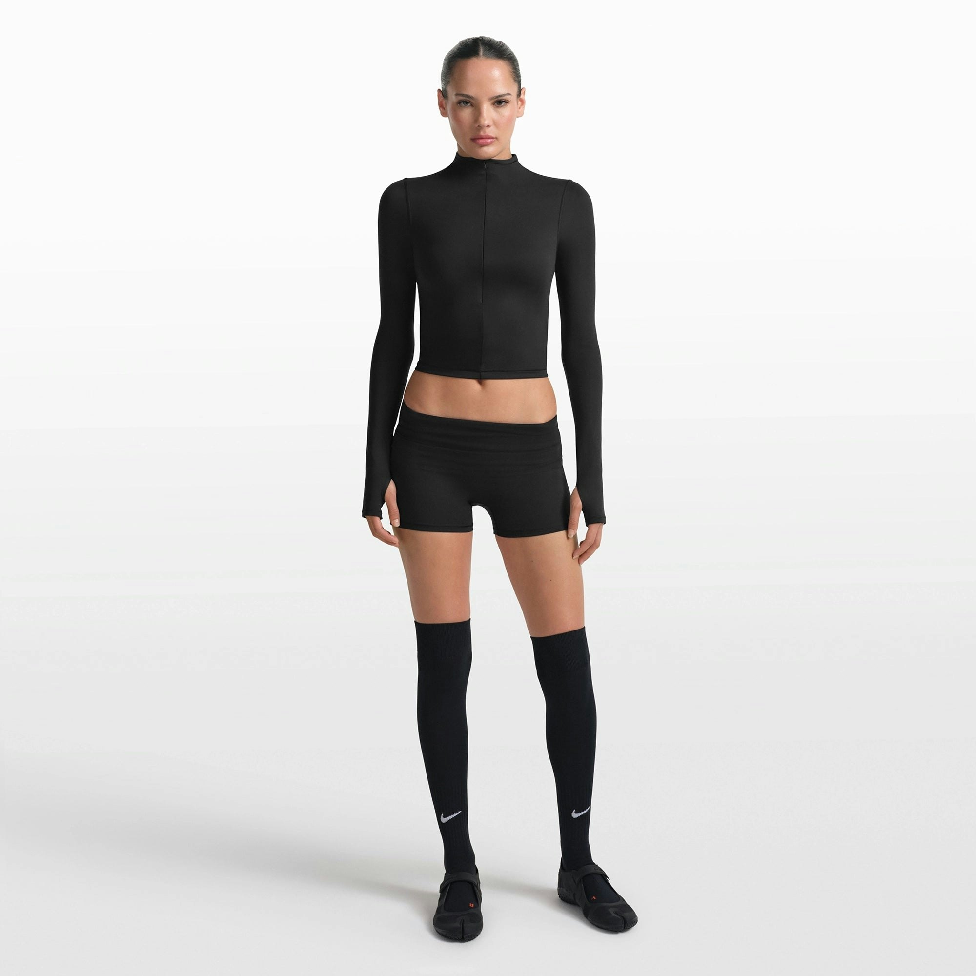 NikeSKIMS MATTE ZIP FRONT TOP | OBSIDIAN ON A MODEL FRONT VIEW @ | FOCUS: 0.0, 1.0, 0.9