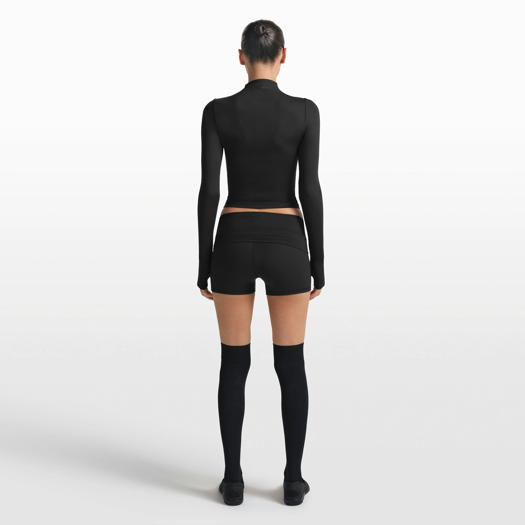 NikeSKIMS MATTE ZIP FRONT TOP | OBSIDIAN ON A MODEL FRONT VIEW @ | FOCUS: 0.0, 1.0, 0.9