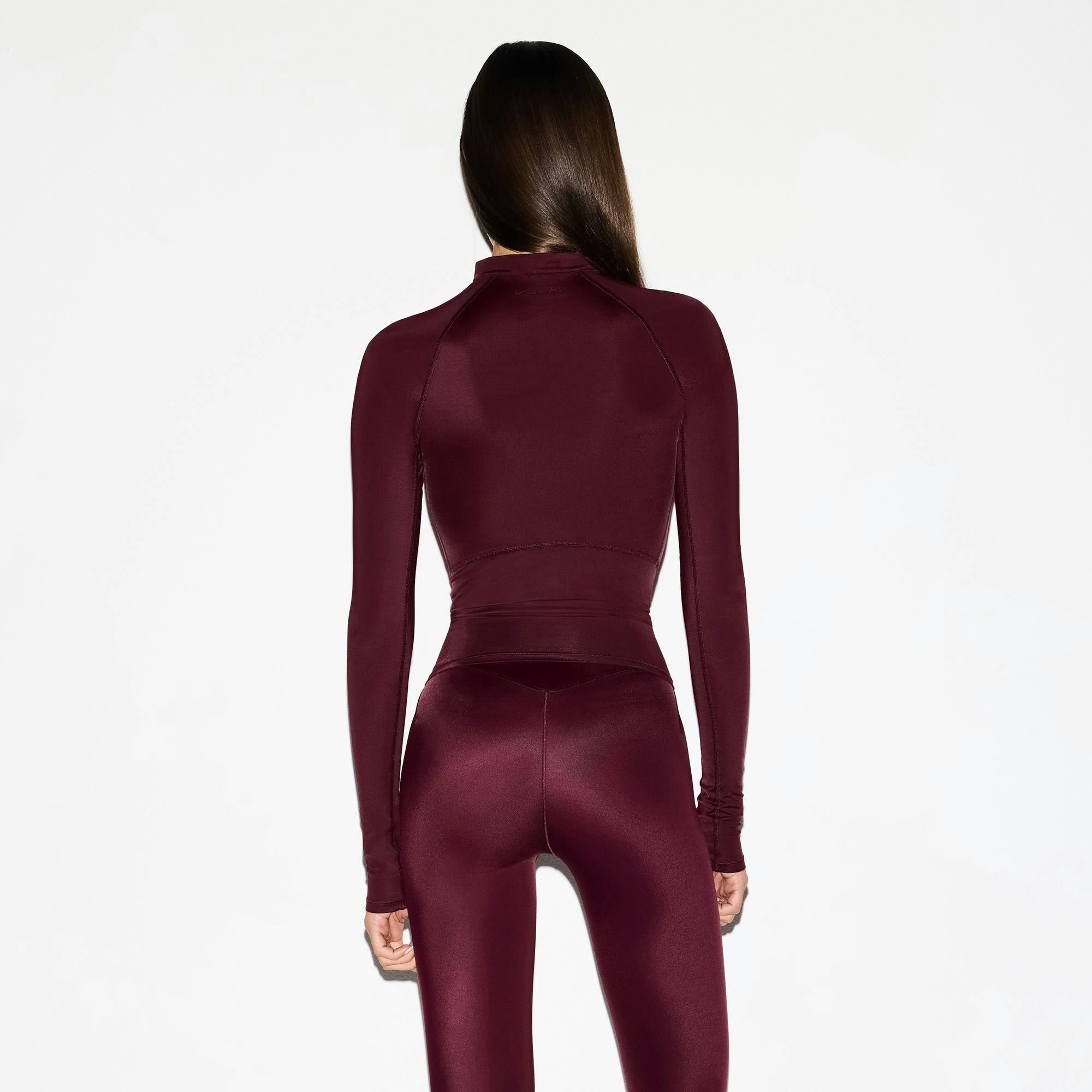 NikeSKIMS SHINE LONG SLEEVE HALF ZIP | CURRANT ON A MODEL SIDE VIEW @ | FOCUS: 0.0, 1.0, 0.9