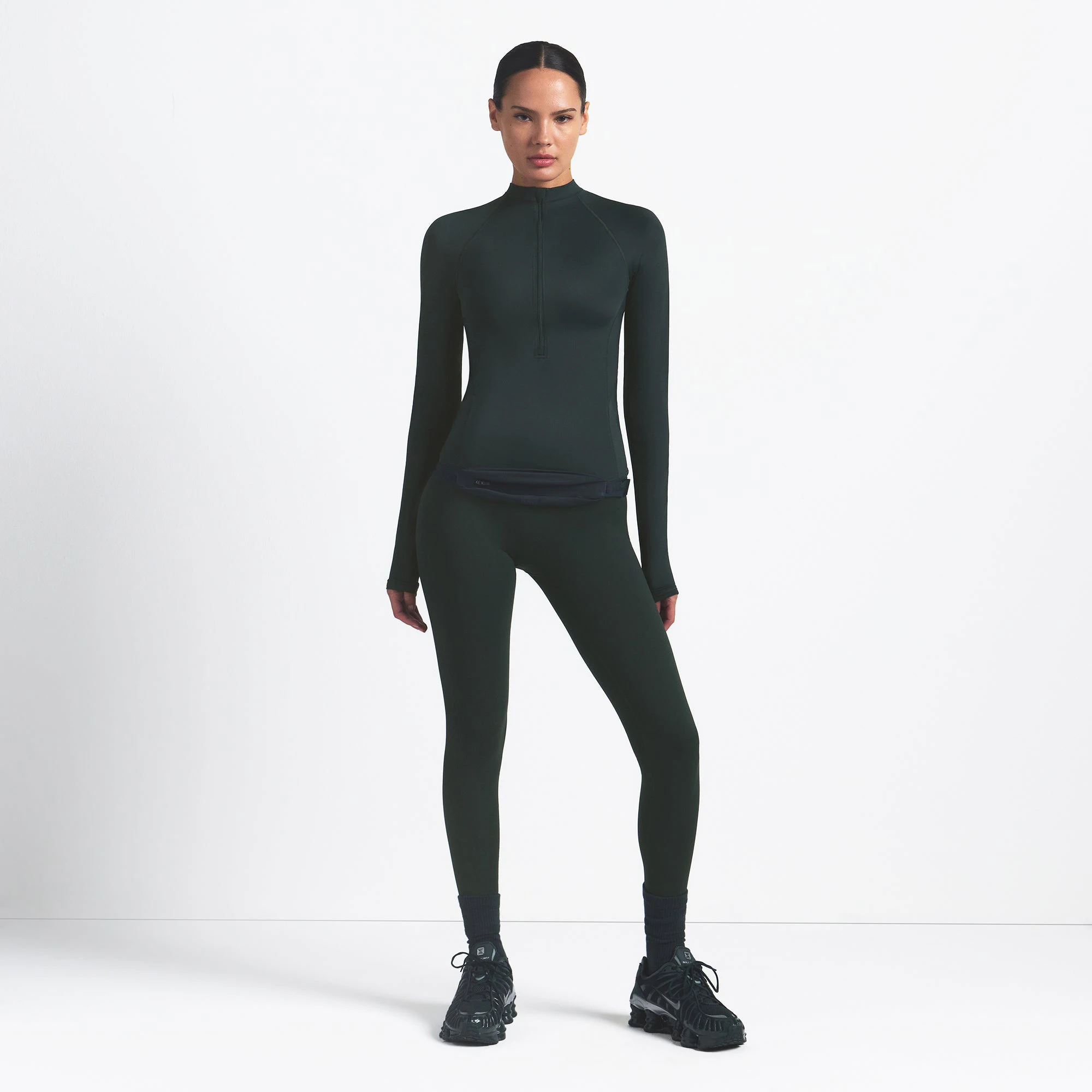 NikeSKIMS SHINE LONG SLEEVE HALF ZIP | DARK TEAL ON A MODEL SIDE VIEW @ | FOCUS: 0.0, 1.0, 0.9