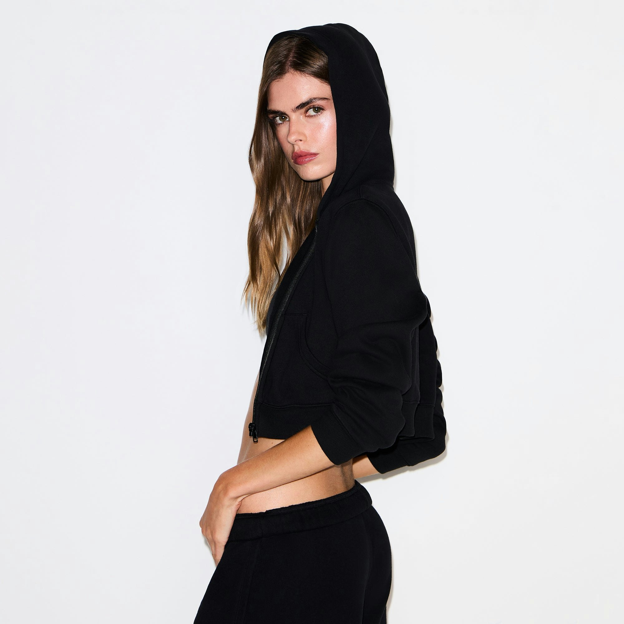 COTTON FLEECE CROPPED ZIP UP HOODIE | ONYX ON A MODEL SIDE VIEW @ | FOCUS: 0.9, 0.1, 0.7
