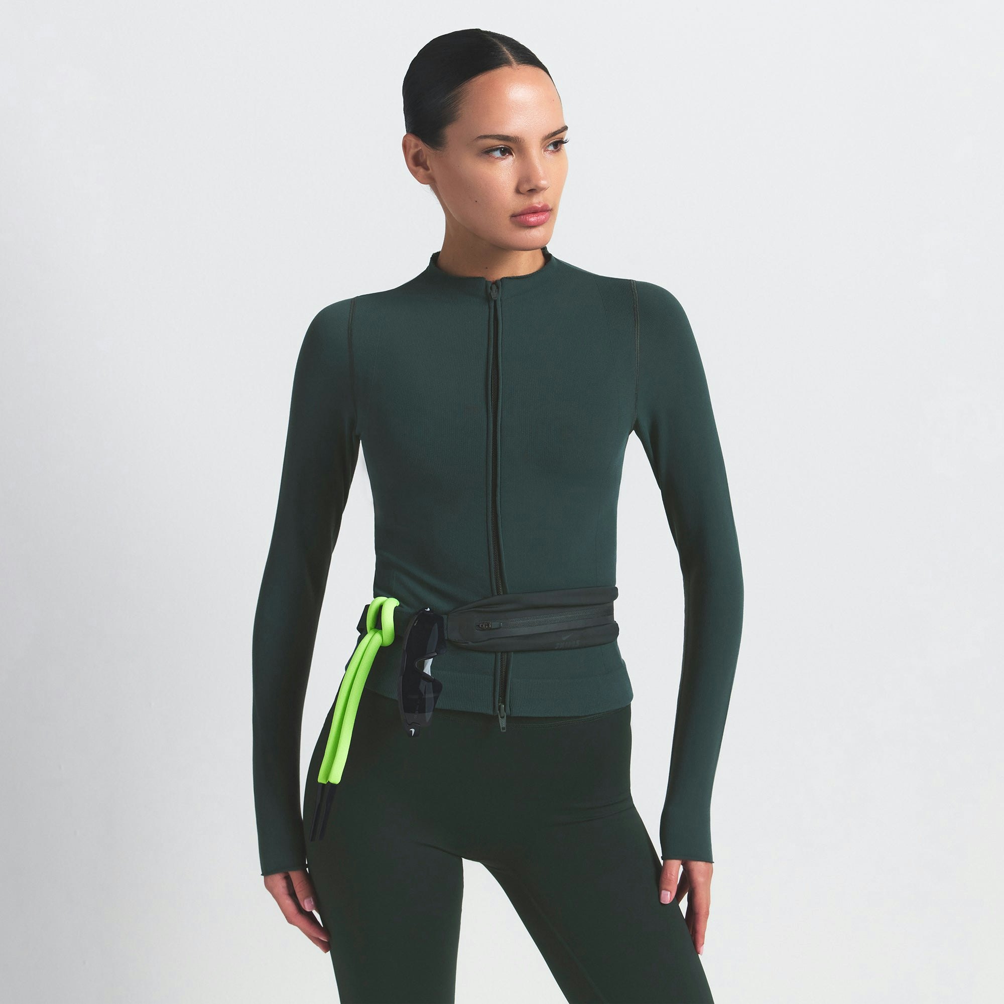 NikeSKIMS VINTAGE SEAMLESS FULL ZIP JACKET | DARK TEAL ON A MODEL SIDE VIEW @ | FOCUS: 0.0, 1.0, 0.9