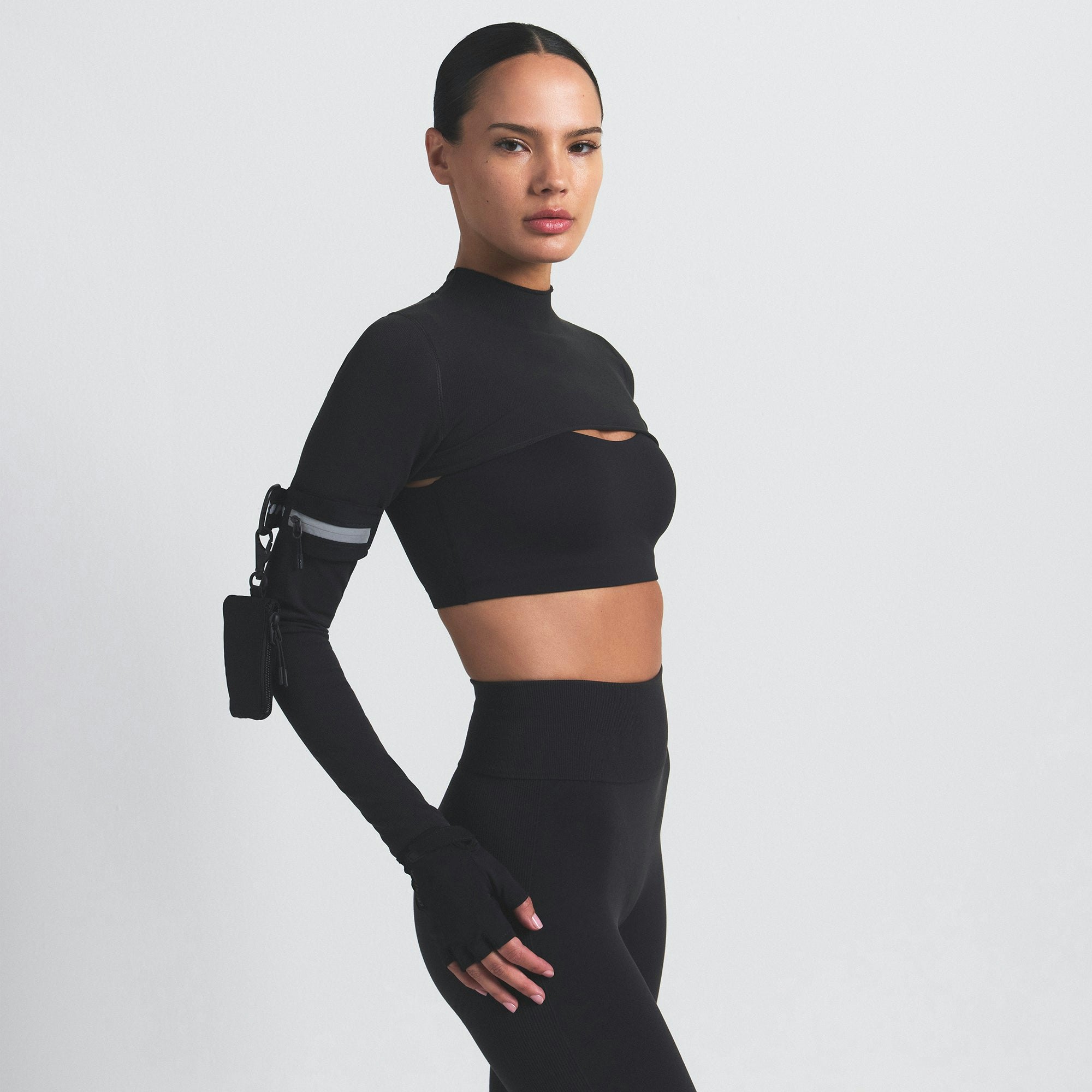 NikeSKIMS VINTAGE SEAMLESS SHRUG | OBSIDIAN ON A MODEL SIDE VIEW @ | FOCUS: 0.9, 0.1, 0.7