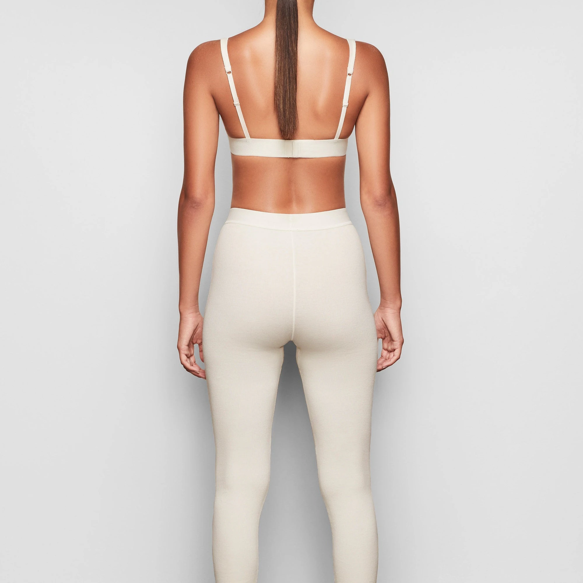 COTTON RIB LEGGING IS SHOWN ON A MODEL POSING IN STYLISTIC CAMPAIGN IMAGERY