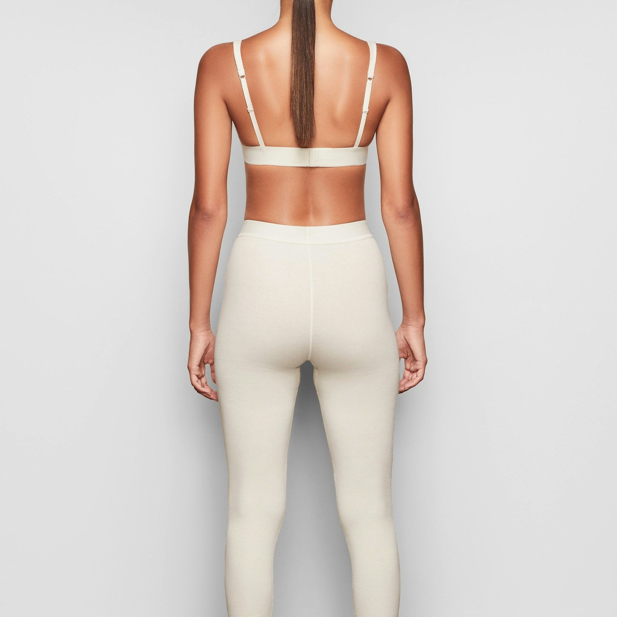 COTTON RIB LEGGING IS SHOWN ON A MODEL POSING IN STYLISTIC CAMPAIGN IMAGERY
