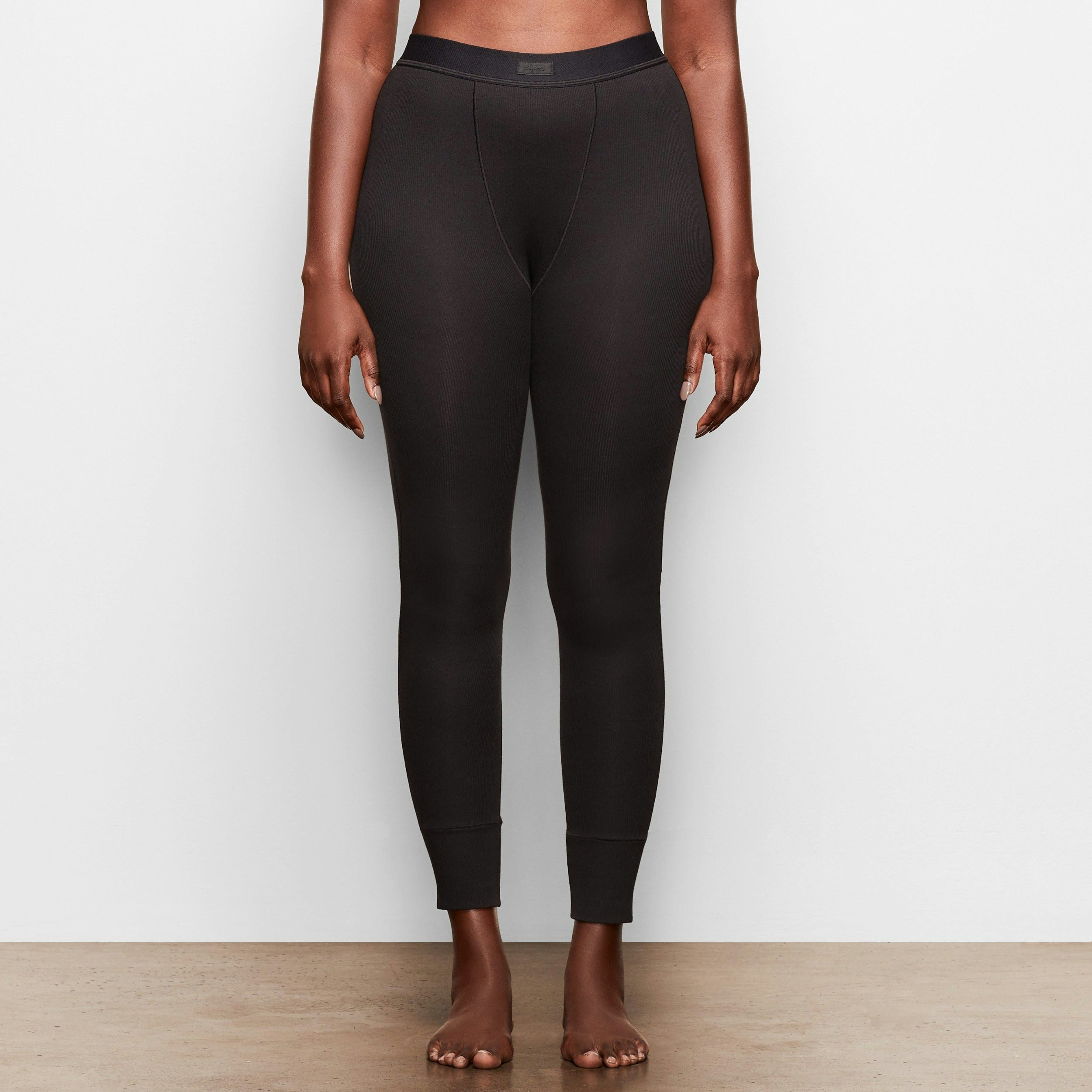 A MODEL STANDS SIDEWAYS SHOWING THE PROFILE OF THE COTTON RIB LEGGING | SOOT