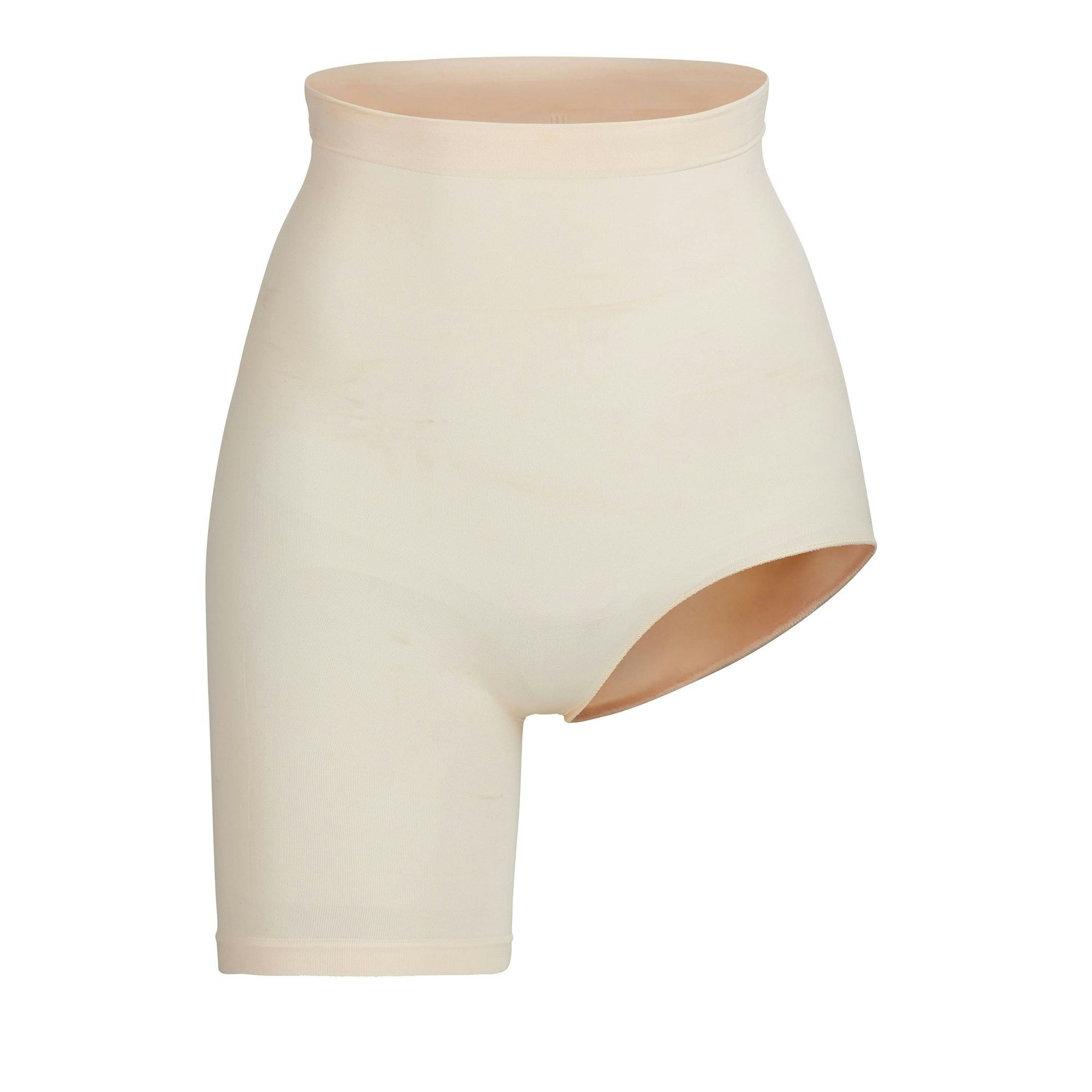 SEAMLESS SCULPT SOLUTION SHORT LEFT LEG EXPOSED | SAND (SHAPEWEAR SHORTS, BODYSUITS) LAYS FLAT ON A WHITE BACKGROUND | FLT
