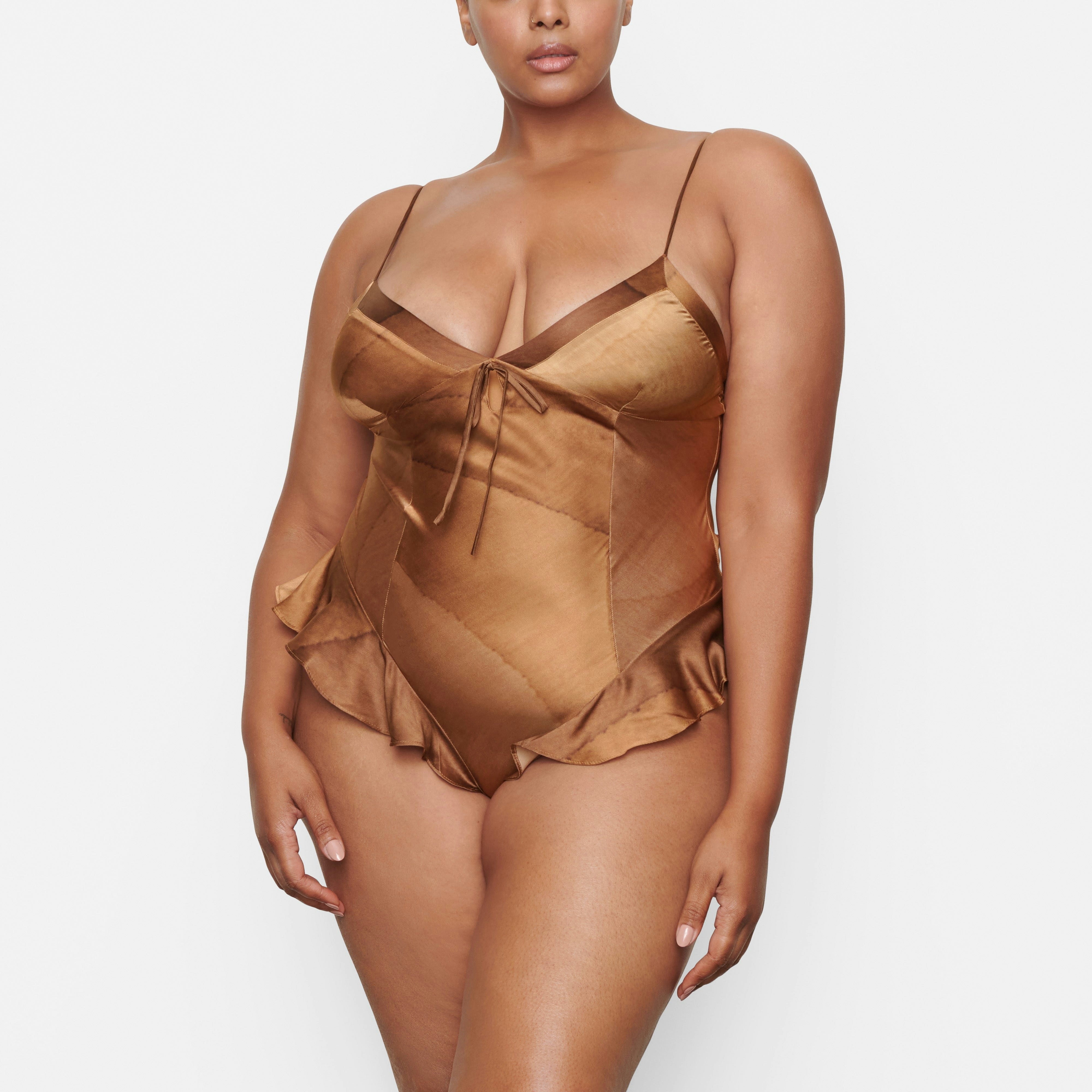 A MODEL STANDS FACING FORWARD WEARING THE SKIMS SILK TEDDY IN OAK | SEE: 2X, 3X, 4X