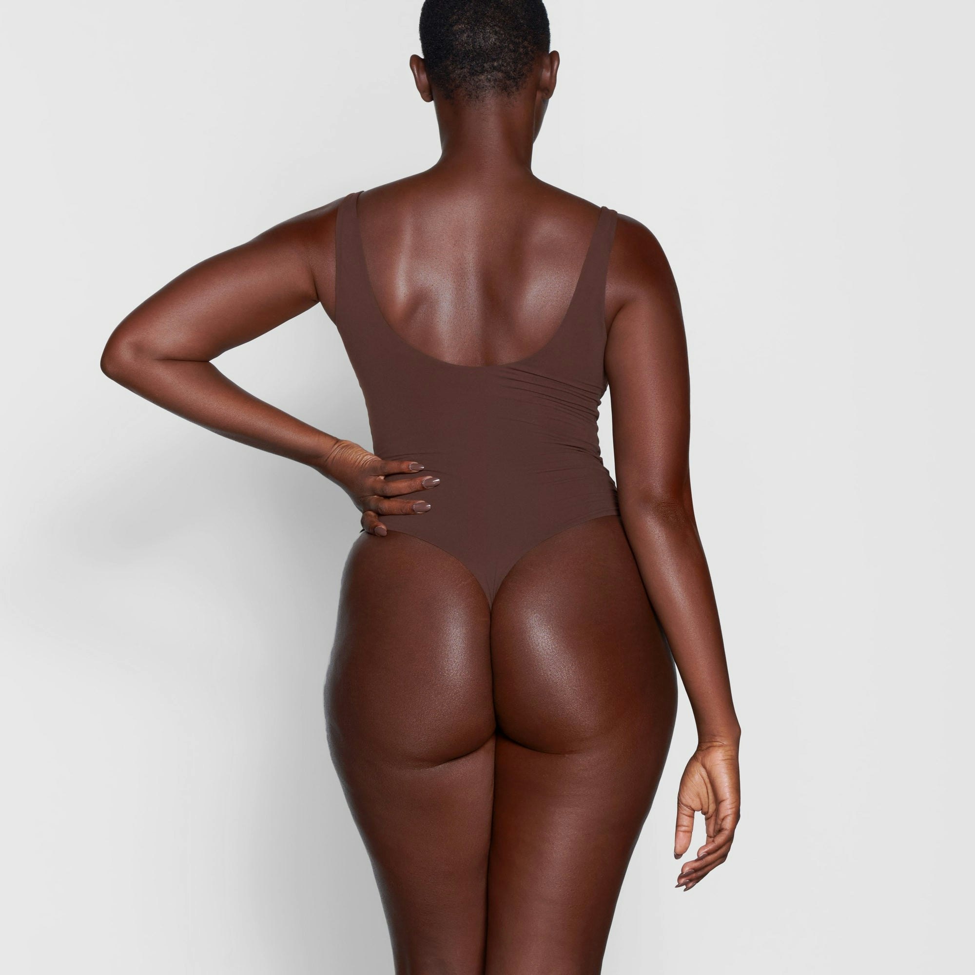 A MODEL STANDS WITH HER BACK TO THE CAMERA SHOWING THE FITS EVERYBODY SQUARE NECK BODYSUIT | COCOA