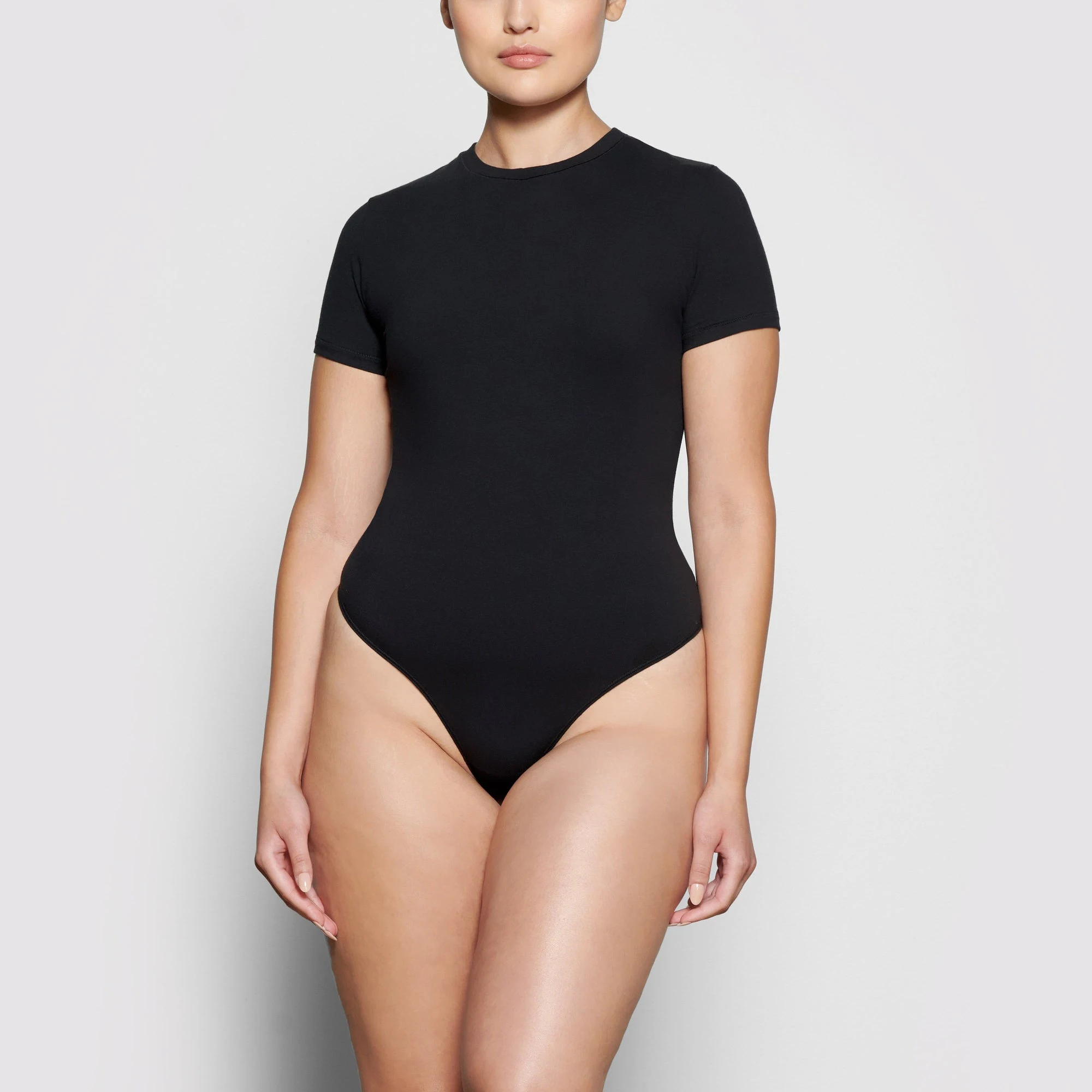 FRONT VIEW OF A MODEL WEARING THE COTTON JERSEY T-SHIRT BODYSUIT 