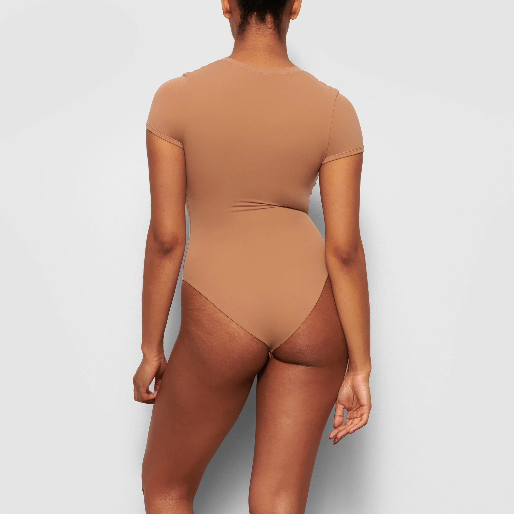 BACK VIEW OF THE FITS EVERYBODY T-SHIRT BODYSUIT ON A MODEL
