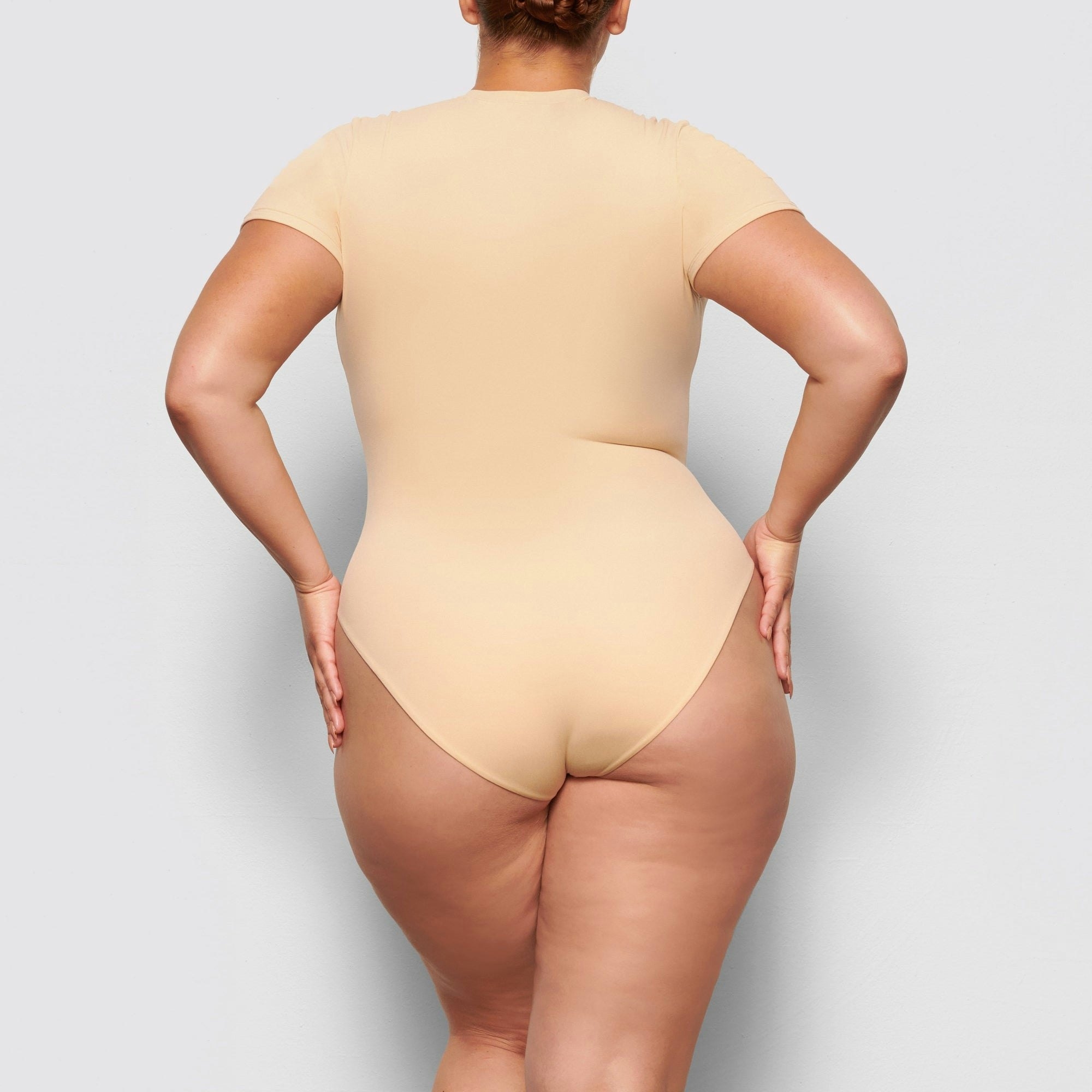 BACK VIEW OF THE FITS EVERYBODY T-SHIRT BODYSUIT ON A MODEL