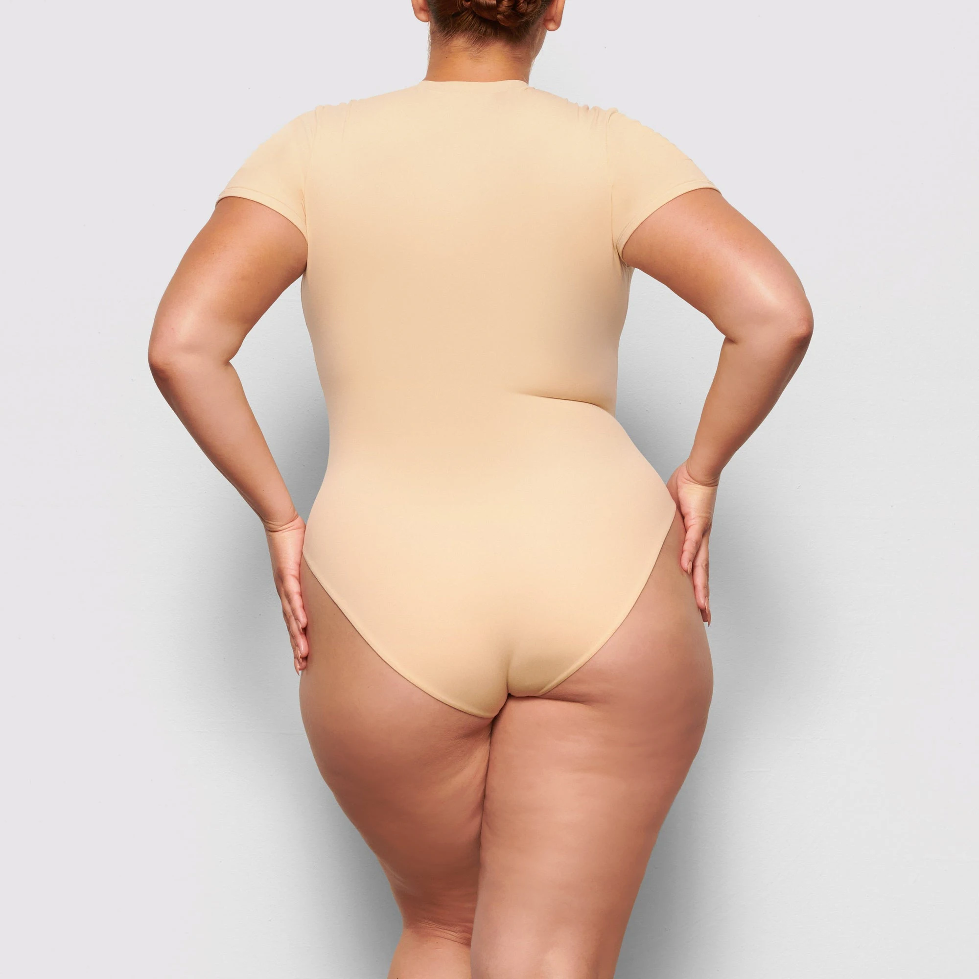 BACK VIEW OF THE FITS EVERYBODY T-SHIRT BODYSUIT ON A MODEL