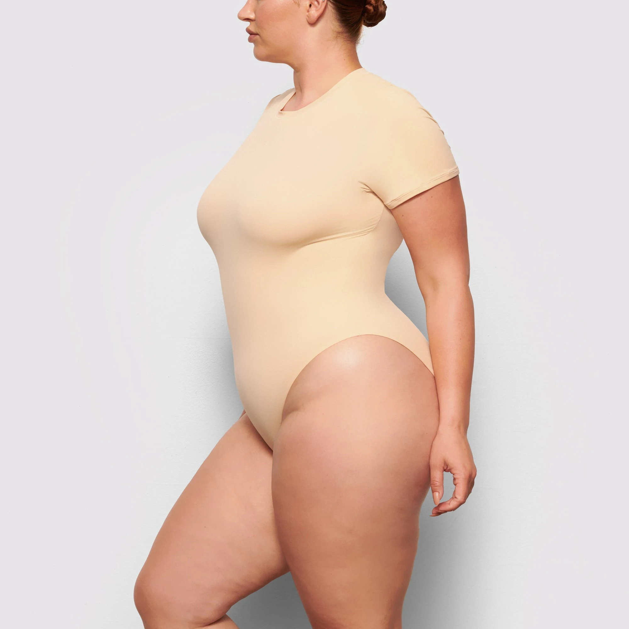 SIDE VIEW OF THE FITS EVERYBODY T-SHIRT BODYSUIT ON A MODEL