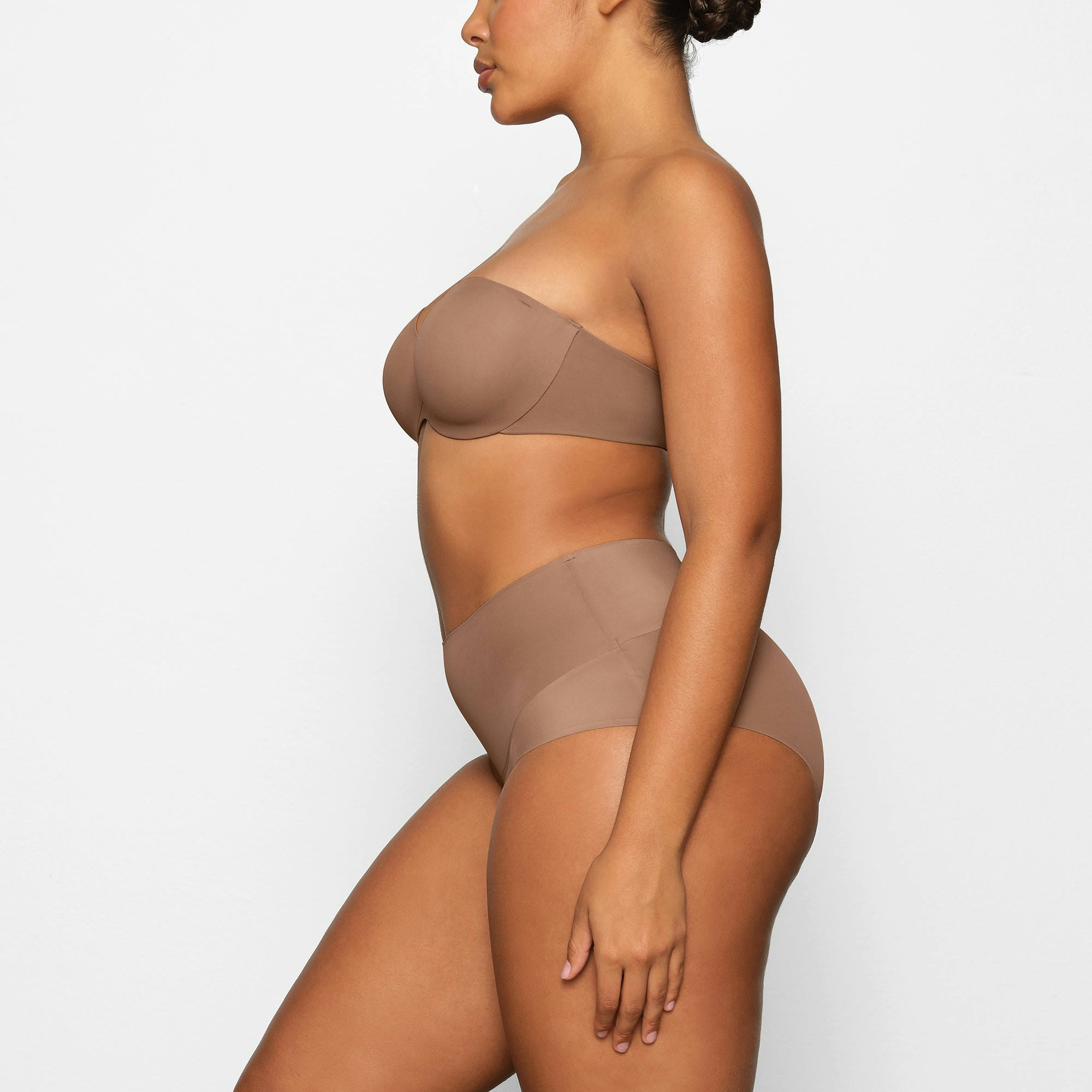 SMOOTHING STRAPLESS BRA WORN BY A MODEL IN SIDE VIEW