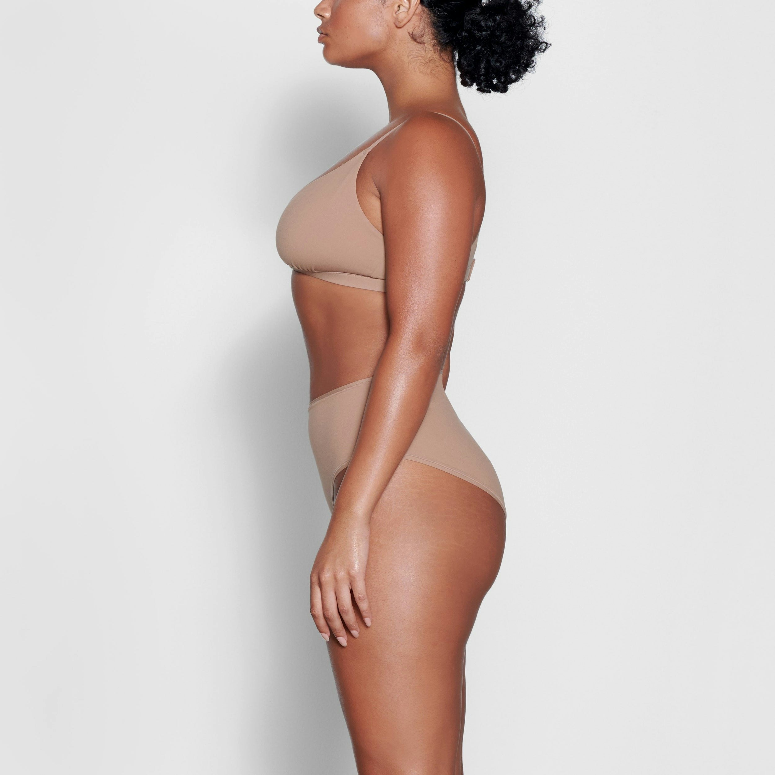 A MODEL STANDS SIDEWAYS SHOWING THE PROFILE OF THE FITS EVERYBODY CROSSOVER BRALETTE | SIENNA