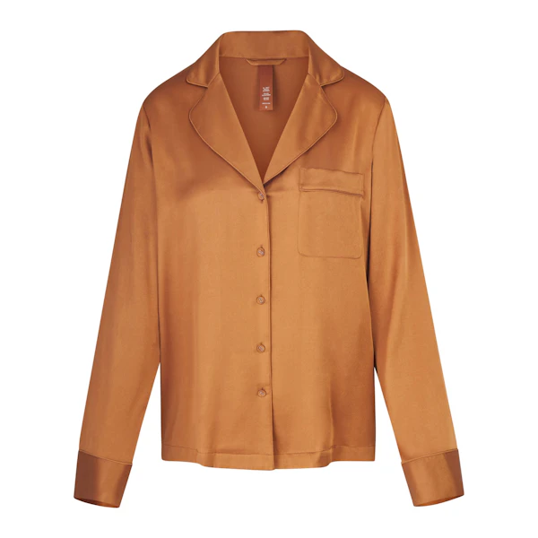 SILK BUTTON UP SHIRT LAYS FLAT ON A WHITE BACKGROUND