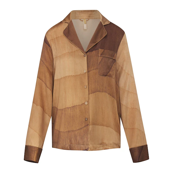 SILK BUTTON UP SHIRT LAYS FLAT ON A WHITE BACKGROUND