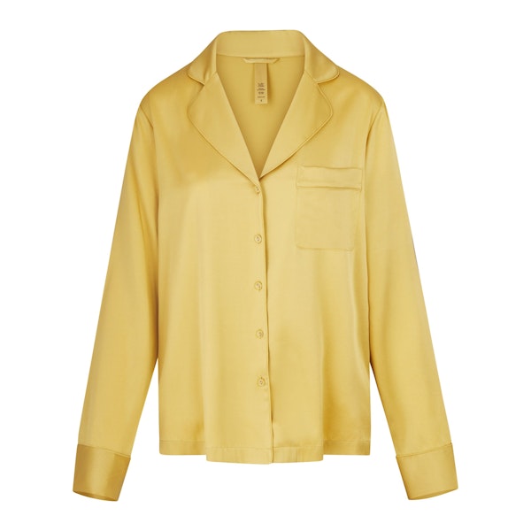 SILK BUTTON UP SHIRT LAYS FLAT ON A WHITE BACKGROUND