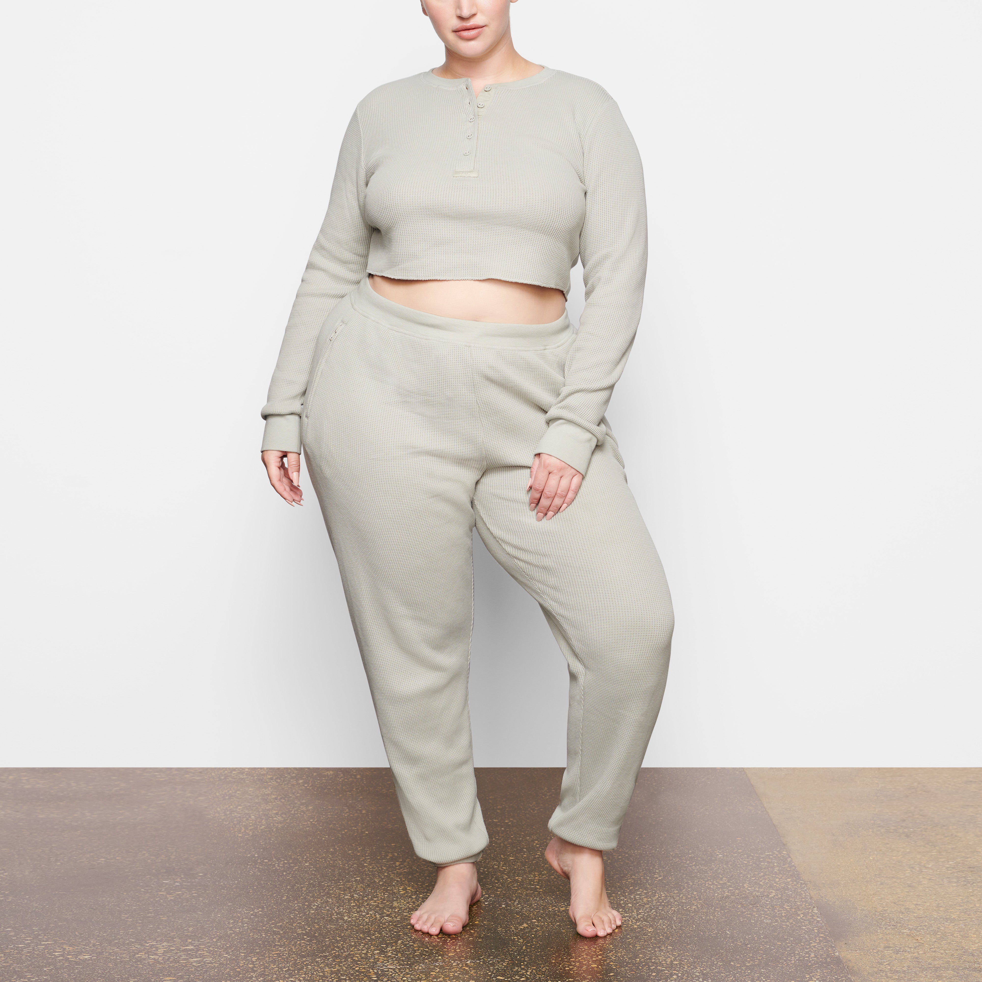 A MODEL STANDS FACING FORWARD WEARING THE SKIMS WAFFLE JOGGER IN TALC | SEE: 2X, 3X, 4X