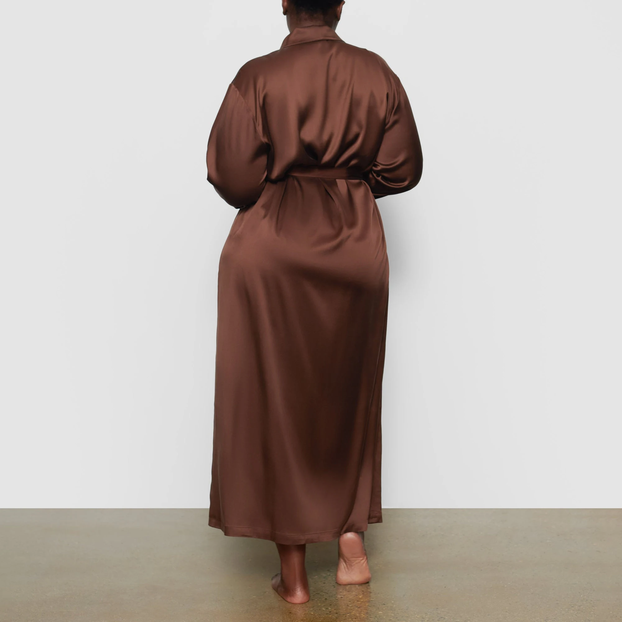 SILK SLEEP ROBE IS SHOWN ON A MODEL POSING IN STYLISTIC CAMPAIGN IMAGERY