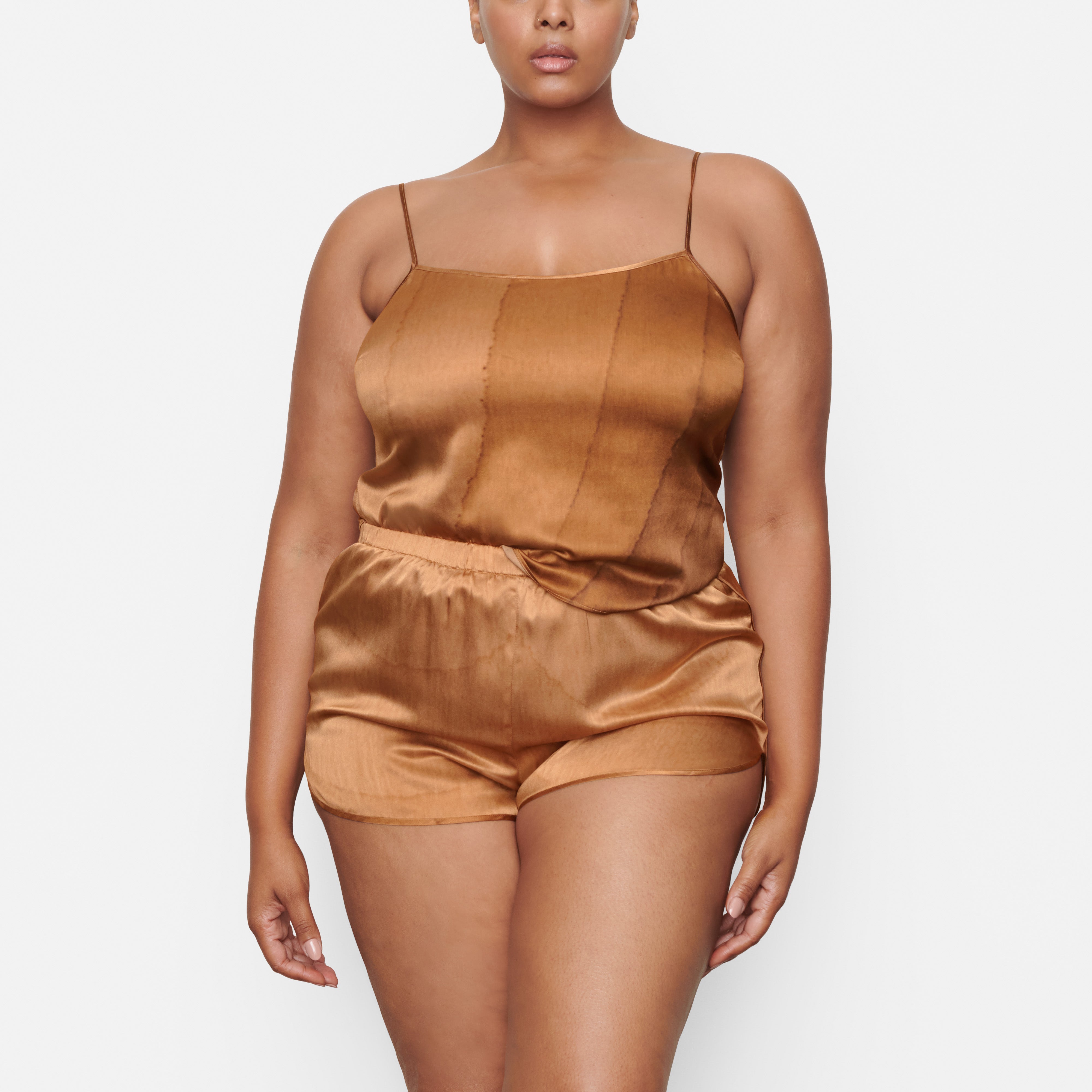 A MODEL STANDS FACING FORWARD WEARING THE SKIMS SILK SLEEP TAP SHORT IN OAK | SEE: 2X, 3X, 4X