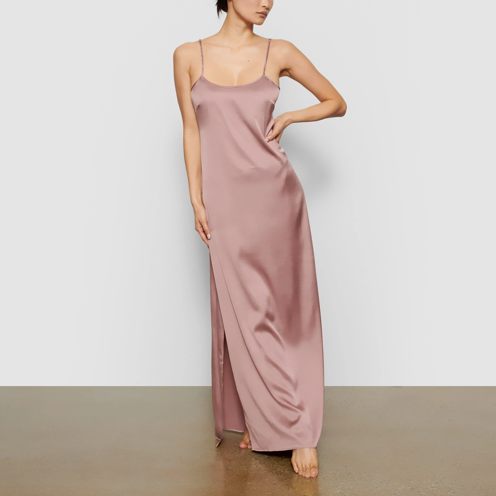 A MODEL STANDS FACING FORWARD WEARING THE SKIMS SILK LONG SLEEP SLIP IN ROSE | SEE: XXS, XS, S
