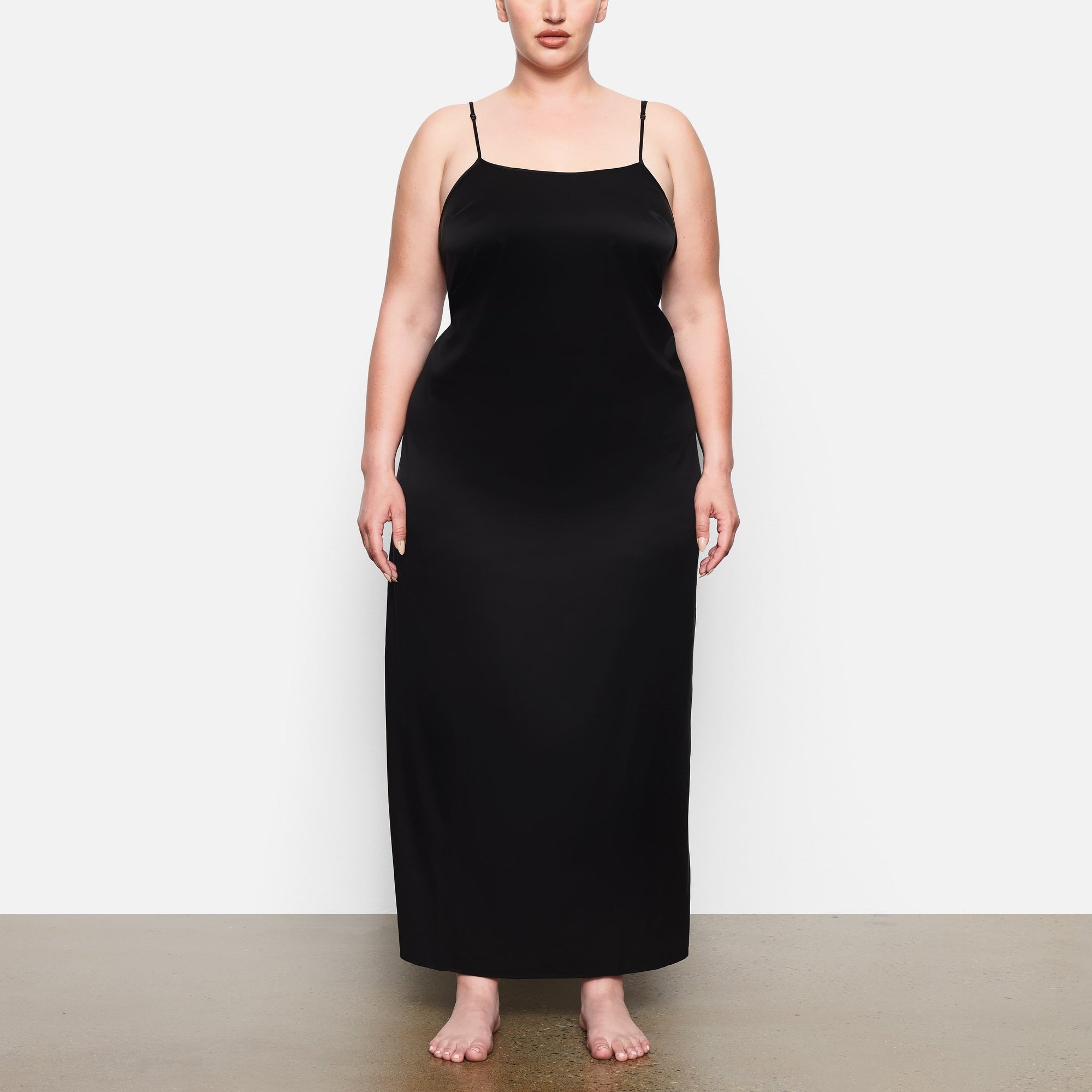 A MODEL STANDS FACING FORWARD WEARING THE SKIMS SILK LONG SLEEP SLIP IN SOOT | SEE: 2X, 3X, 4X