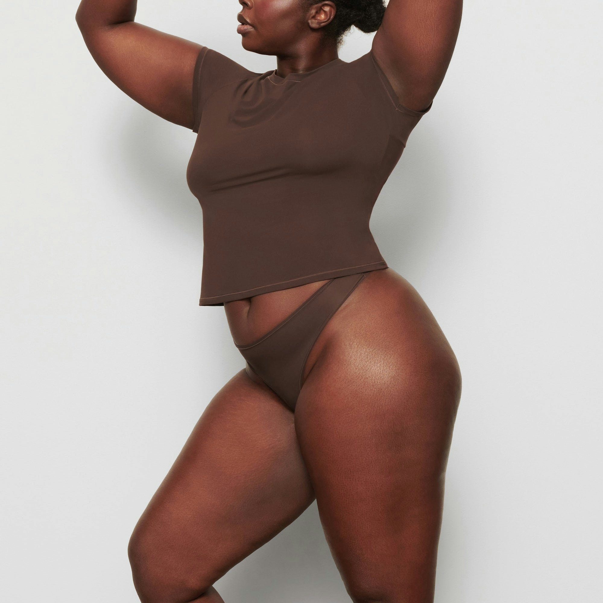 A MODEL STANDS SIDEWAYS SHOWING THE PROFILE OF THE FITS EVERYBODY T-SHIRT | COCOA