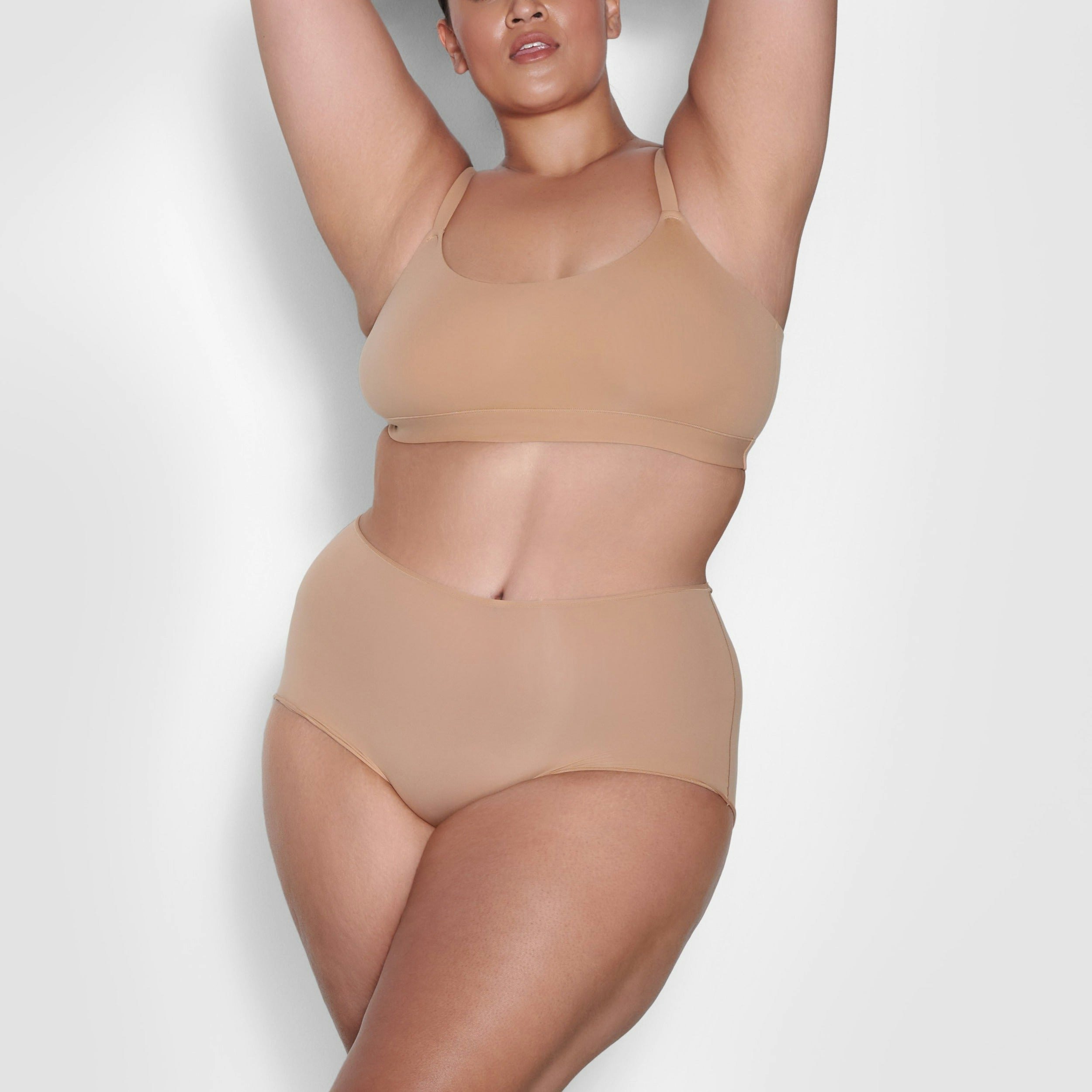 A MODEL STANDS FACING FORWARD WEARING THE FITS EVERYBODY BOY SHORT | OCHRE