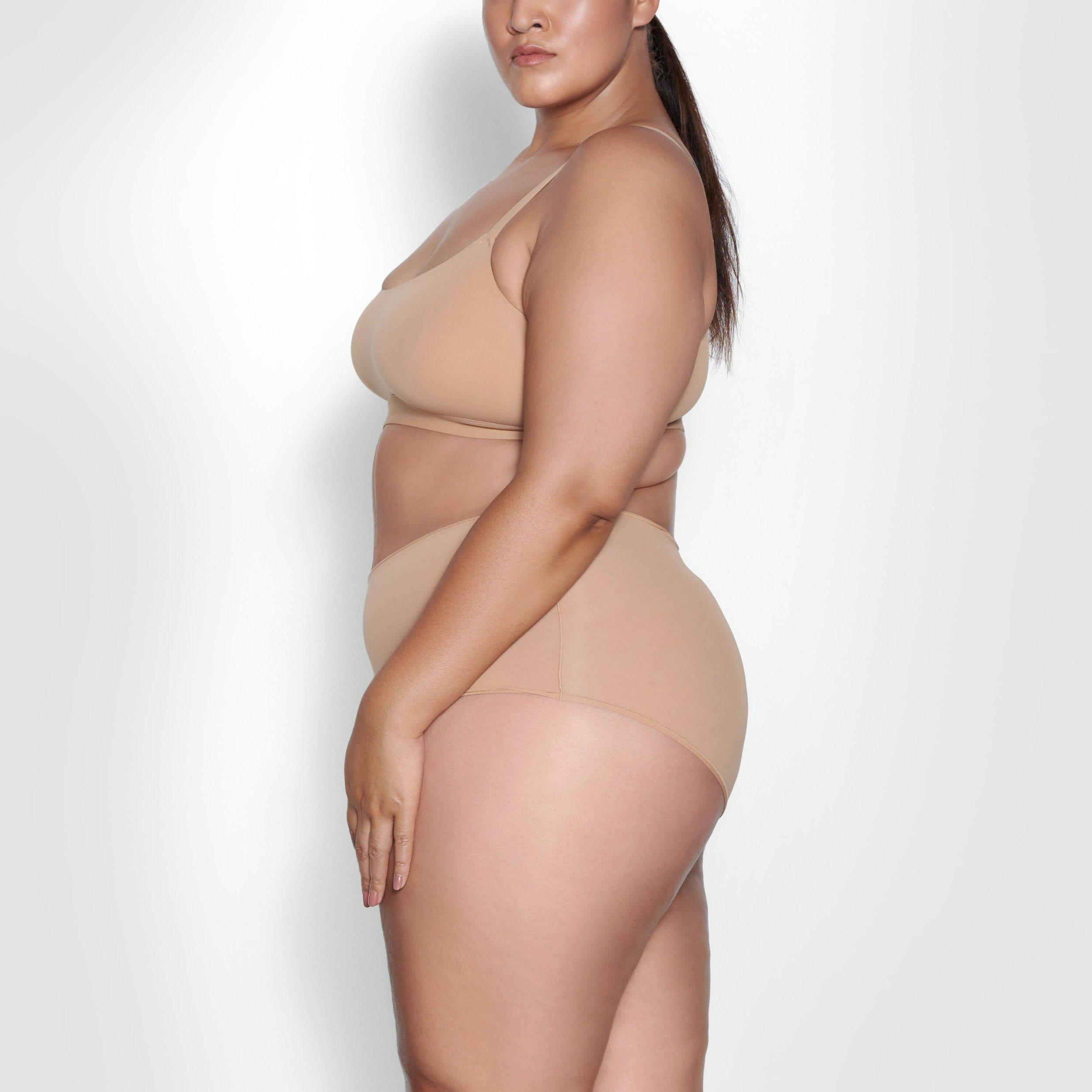 A MODEL STANDS SIDEWAYS SHOWING THE PROFILE OF THE FITS EVERYBODY BOY SHORT | OCHRE