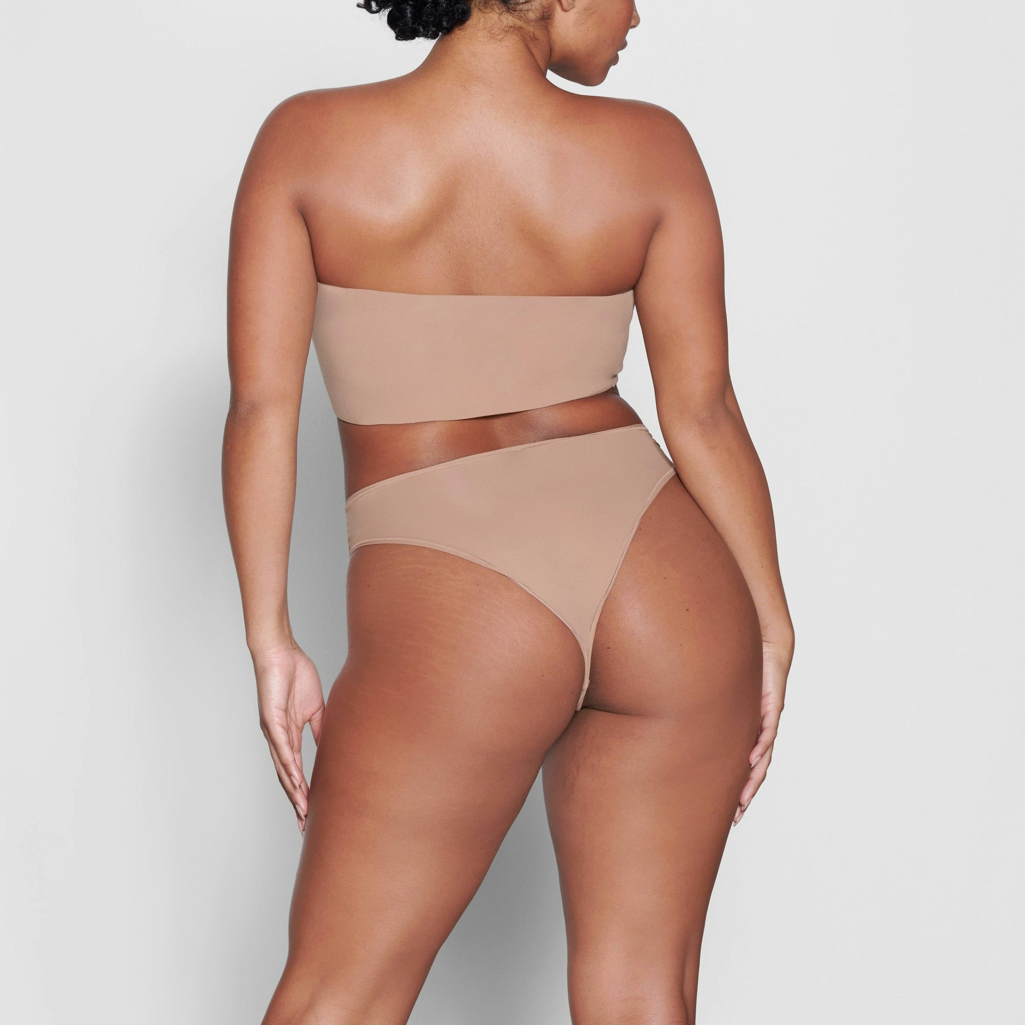 A MODEL STANDS WITH HER BACK TO THE CAMERA SHOWING THE FITS EVERYBODY CHEEKY BRIEF | SIENNA