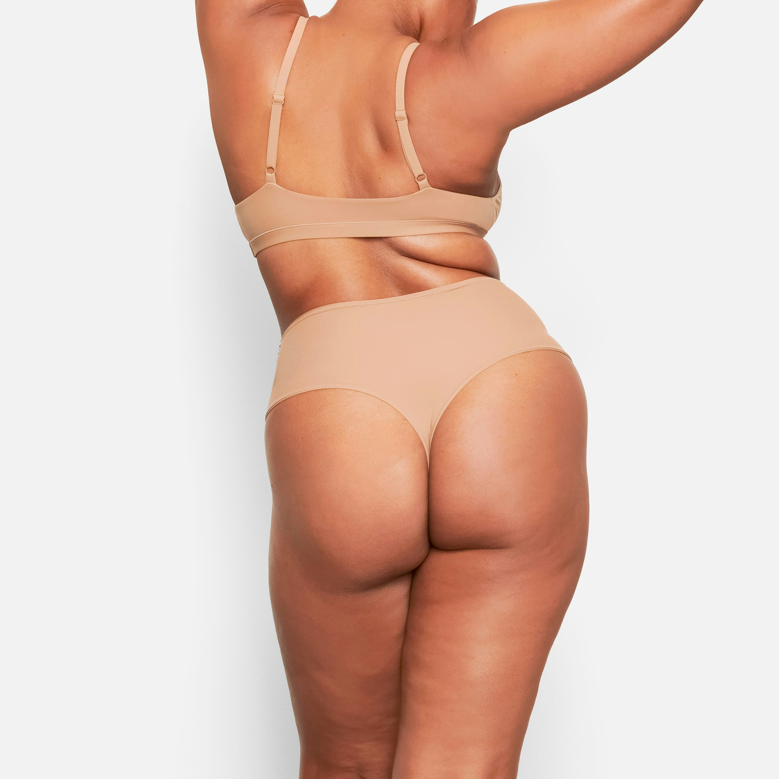 A MODEL STANDS WITH HER BACK TO THE CAMERA SHOWING THE FITS EVERYBODY HIGH WAISTED THONG | SIENNA
